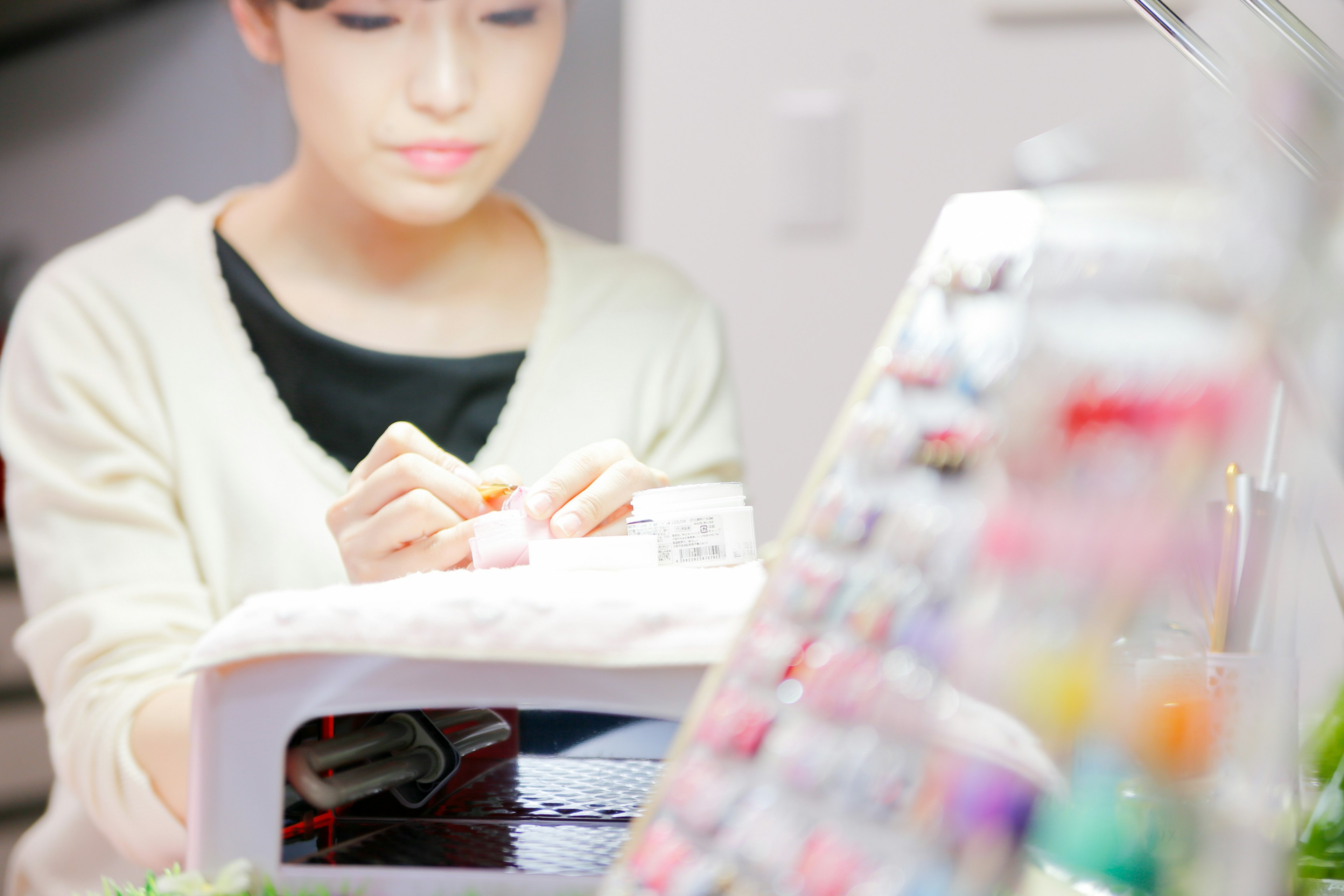 A woman working on a sewing machine with colorful threads in the background