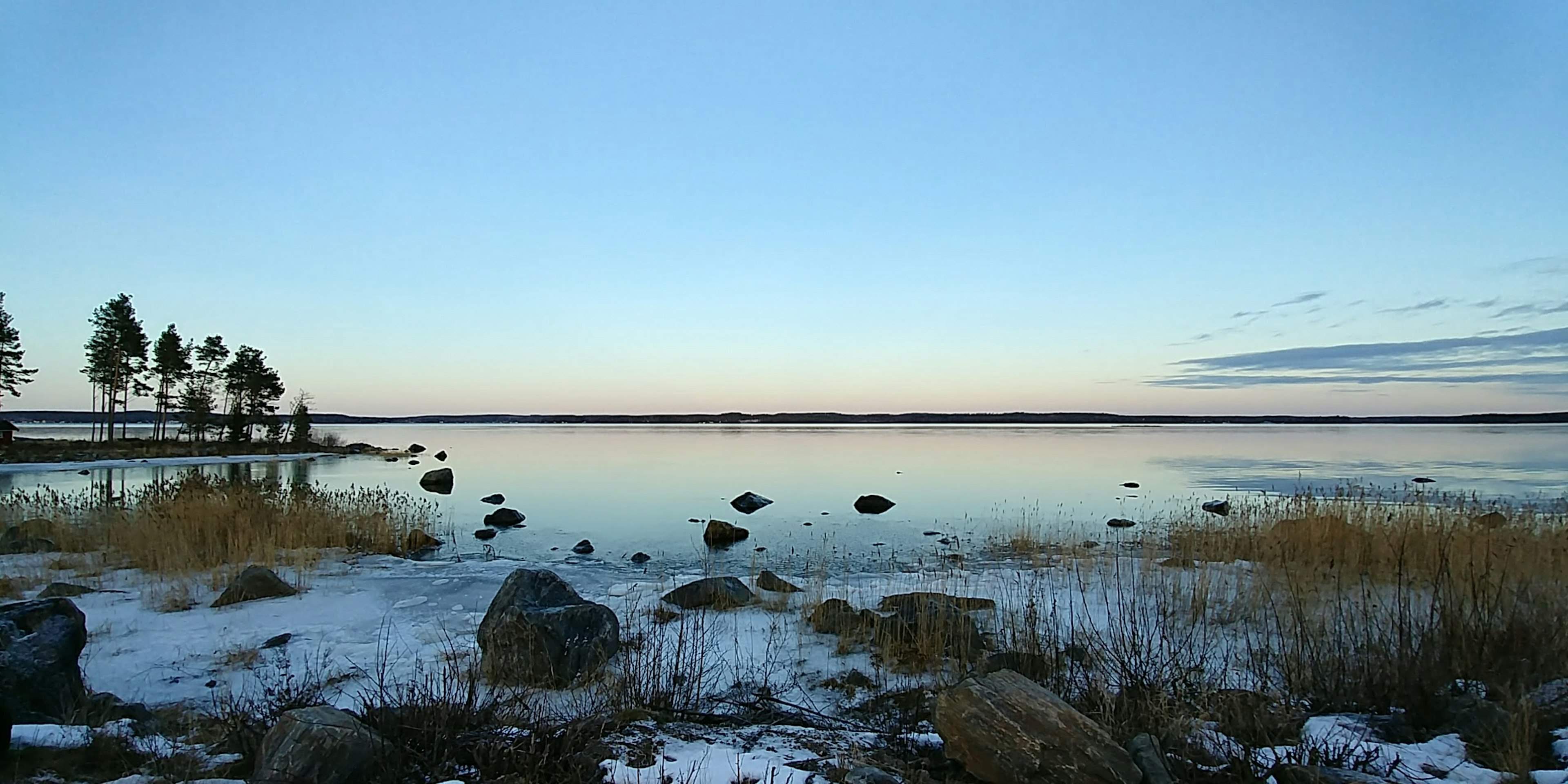 Ruhige Landschaft eines Sees mit schneebedeckten Ufern