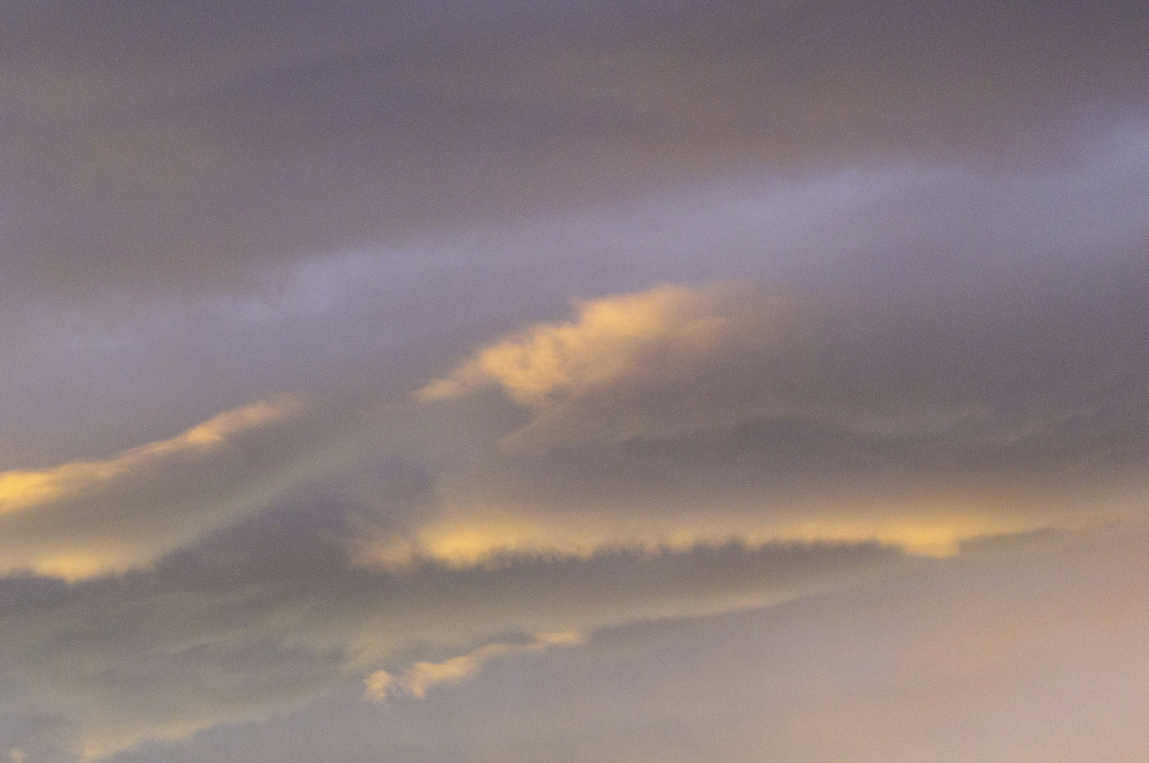 Ciel avec des nuages violets et une lumière dorée