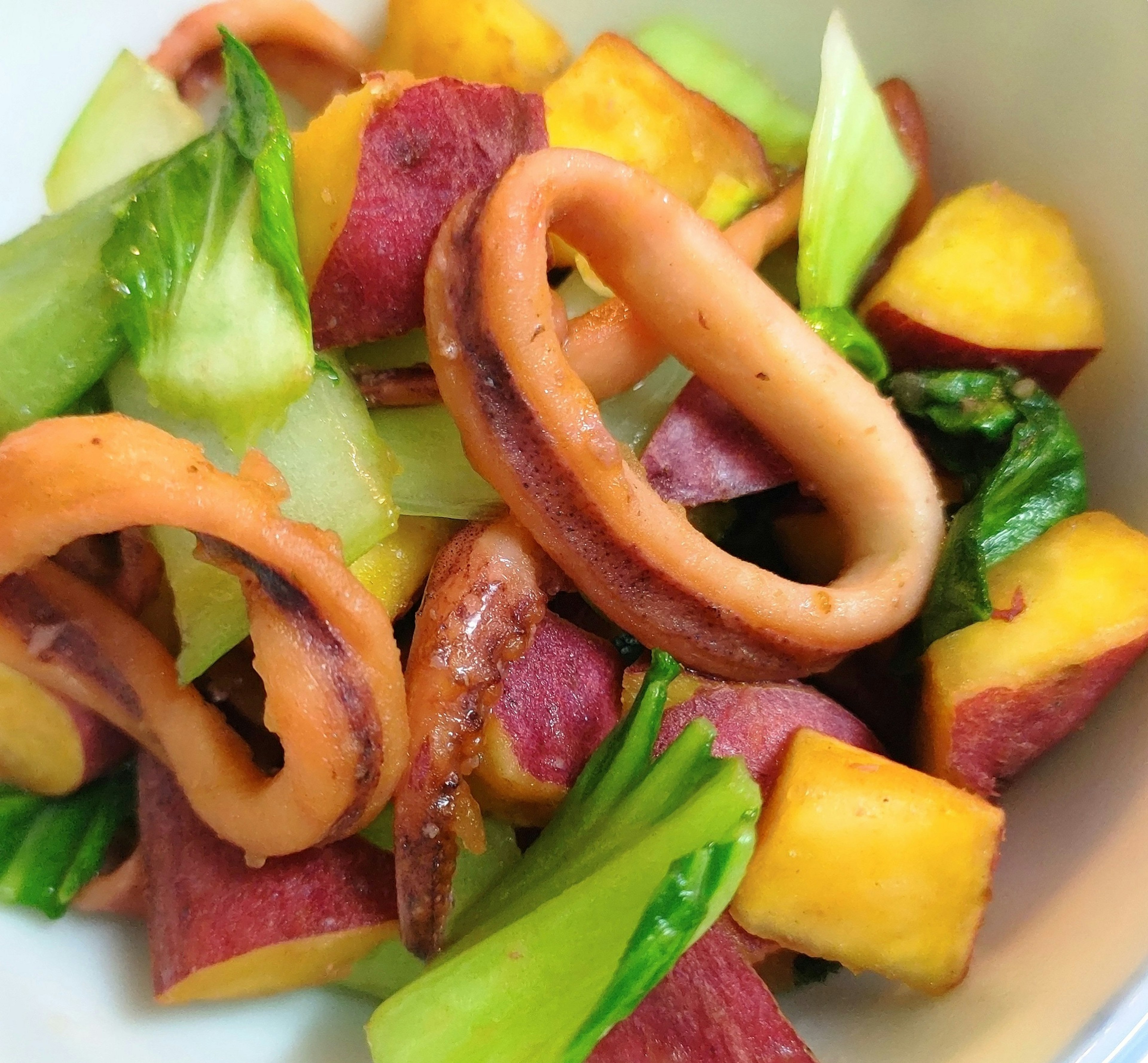 Salad with squid and sweet potato served with fresh vegetables