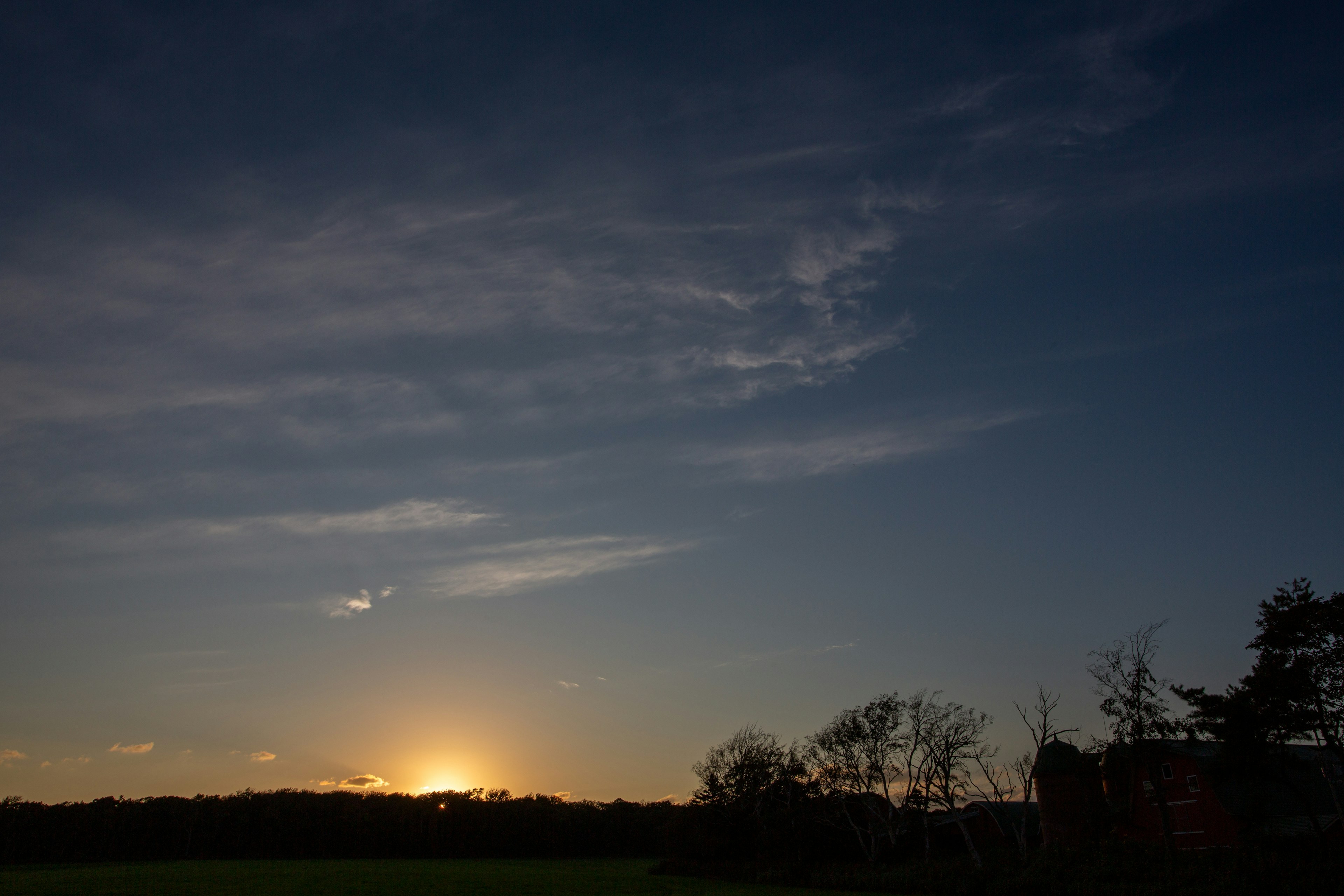 Sonnenuntergangslandschaft mit blauem Himmel und schwebenden Wolken