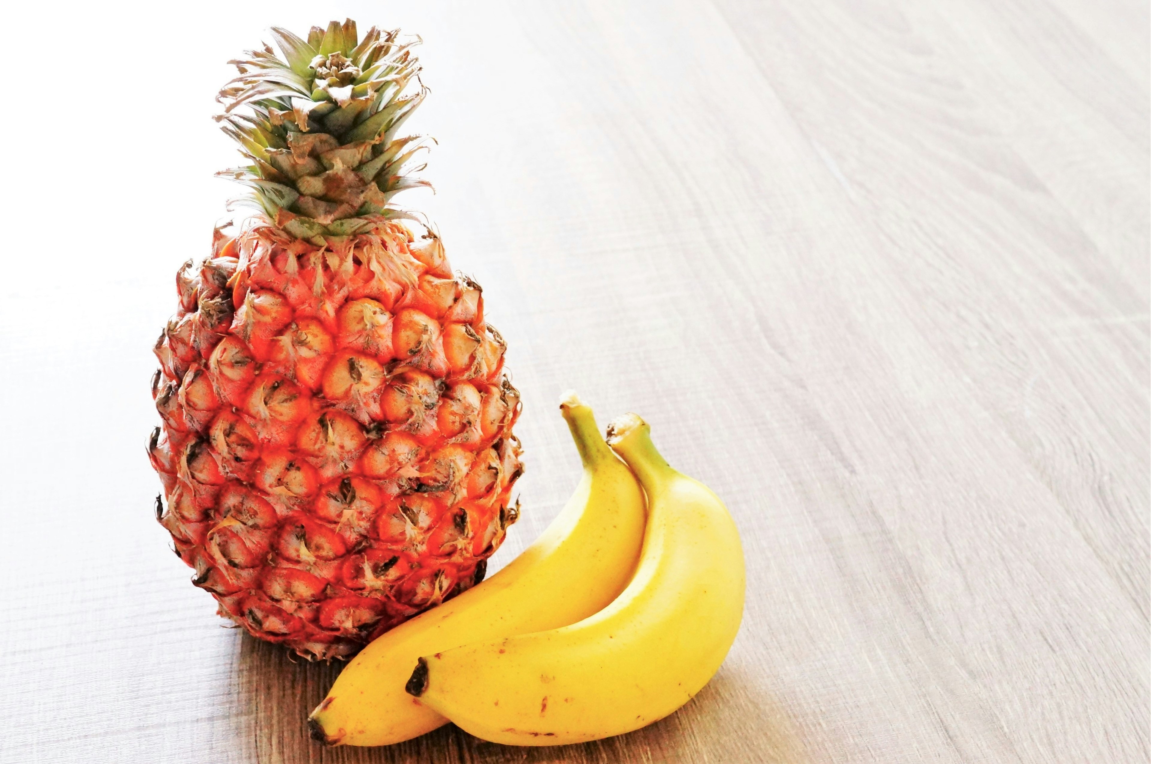 Ananas et bananes sur une table en bois