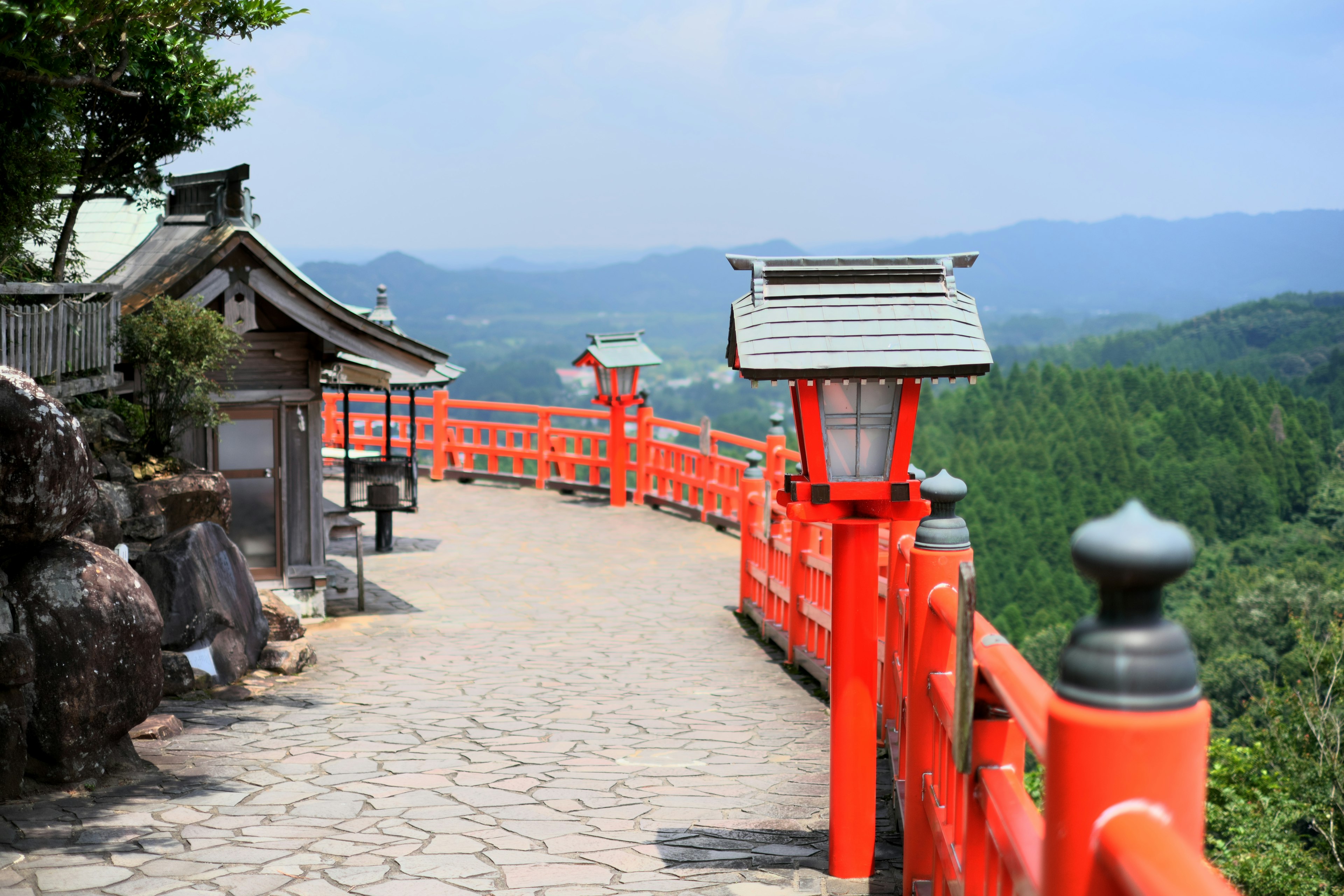 Scenic pathway with red railing and mountains in the background