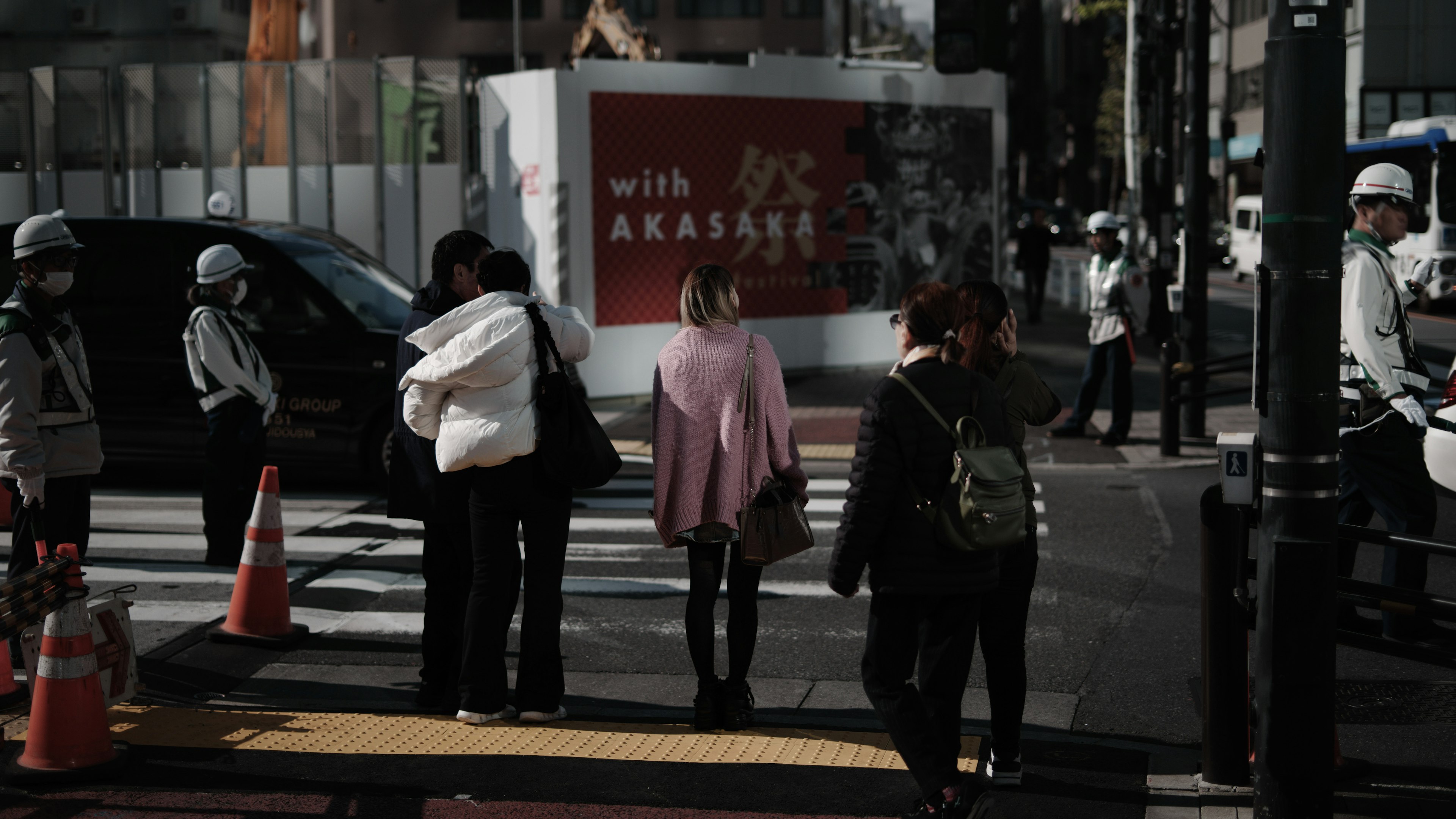 Personas cruzando una calle en un entorno urbano japonés