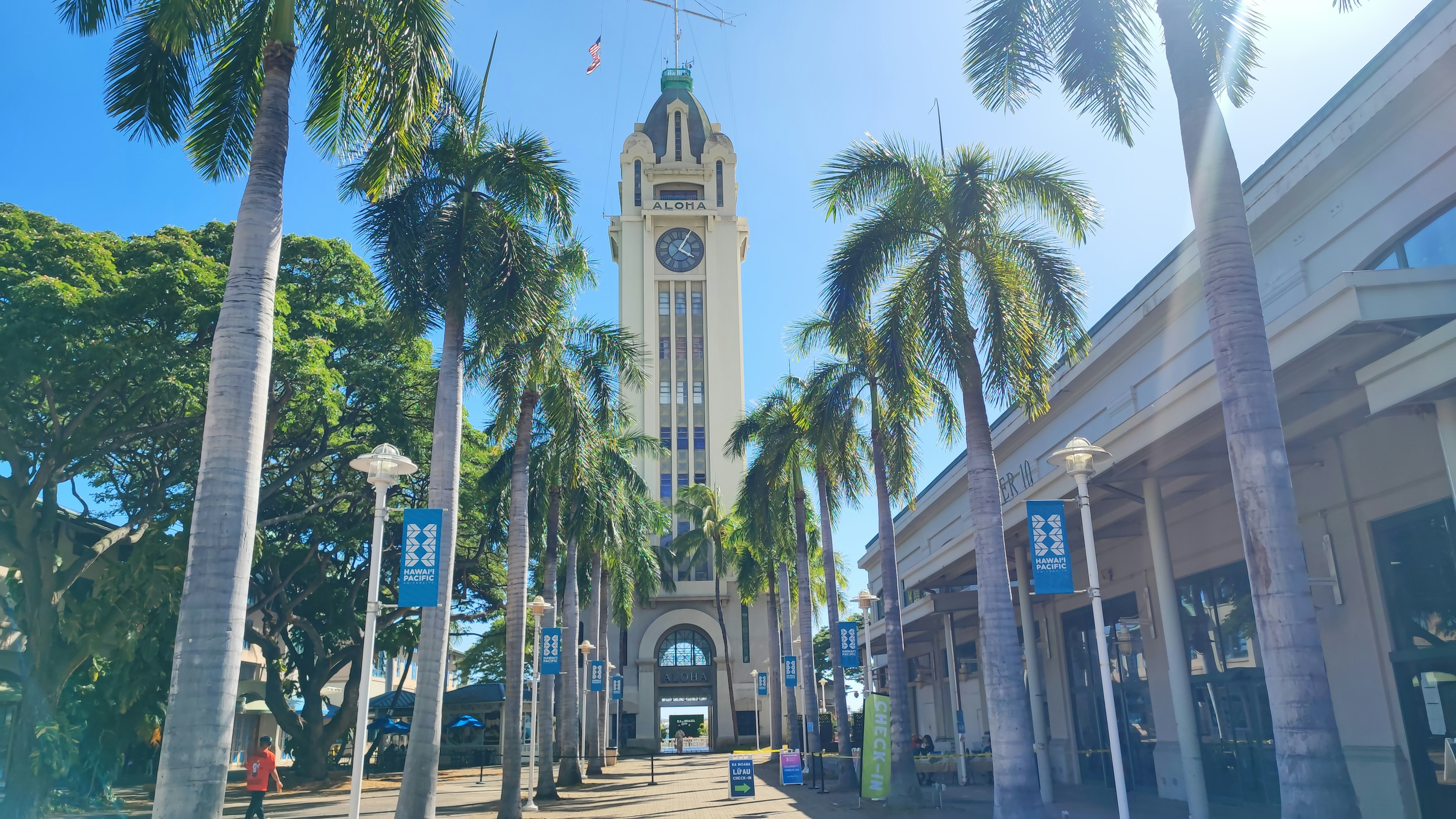 Una vista brillante con una torre del reloj y palmeras