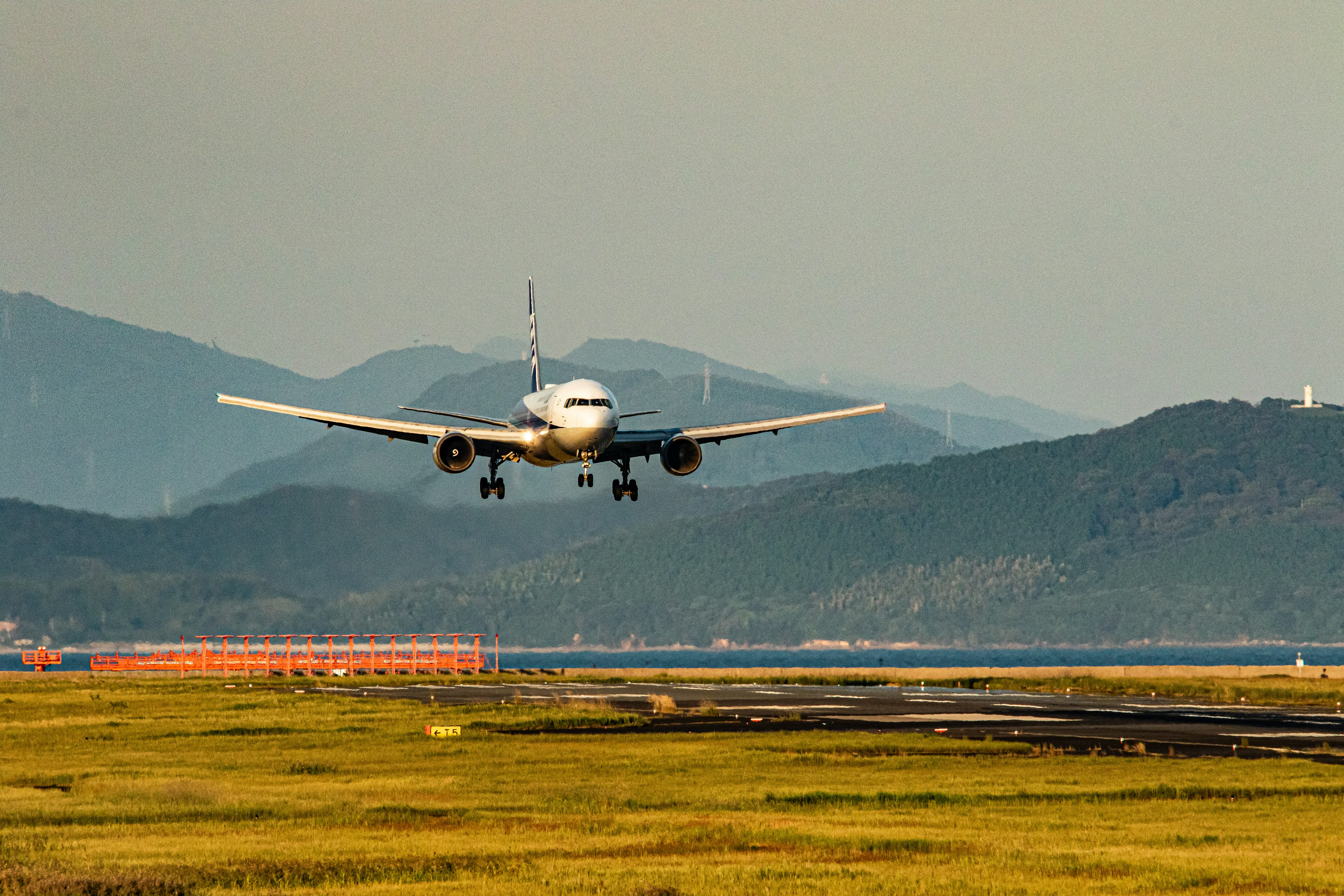 Airplane landing with mountains in the background