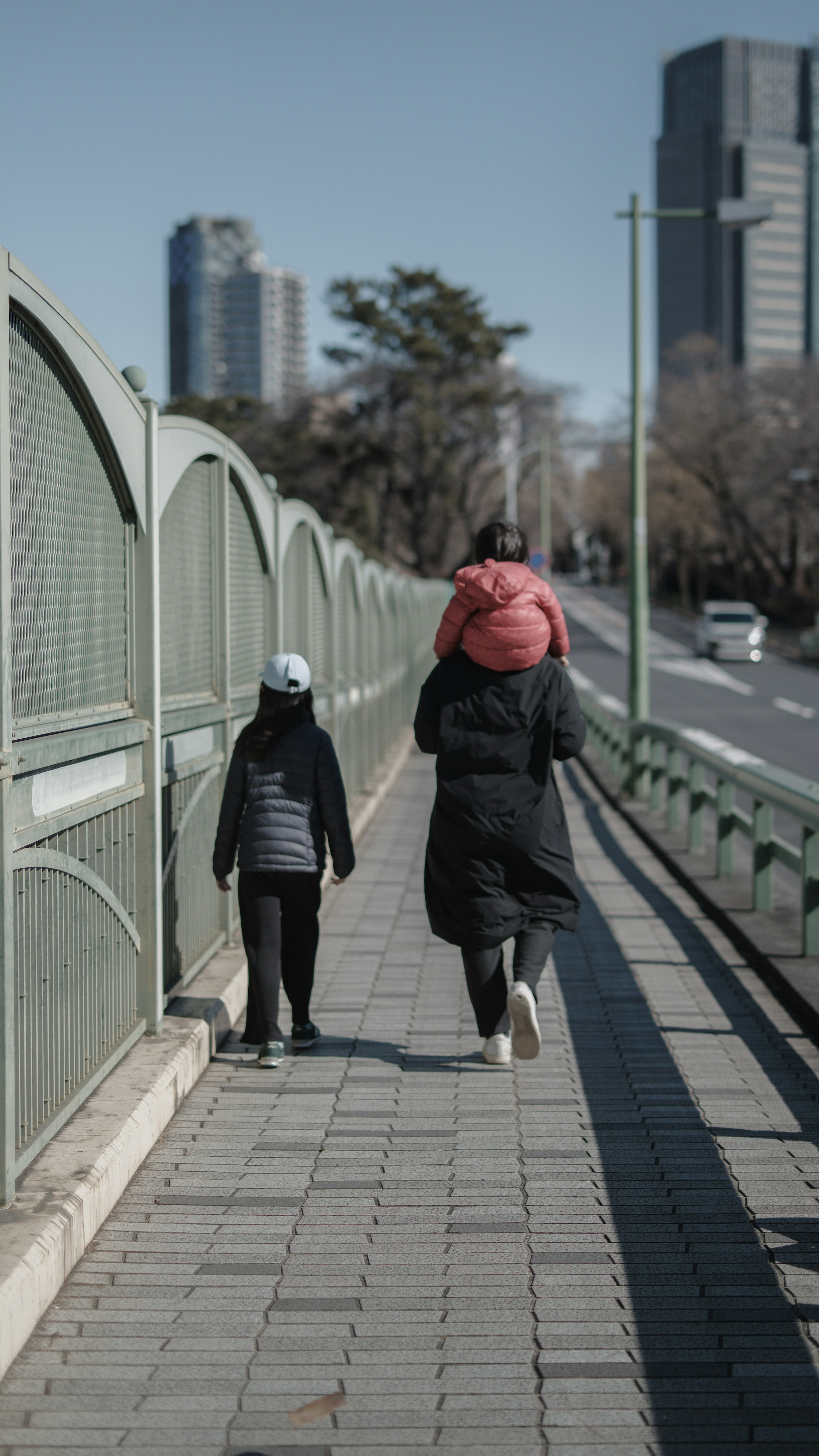 A parent walking with a child on a bridge