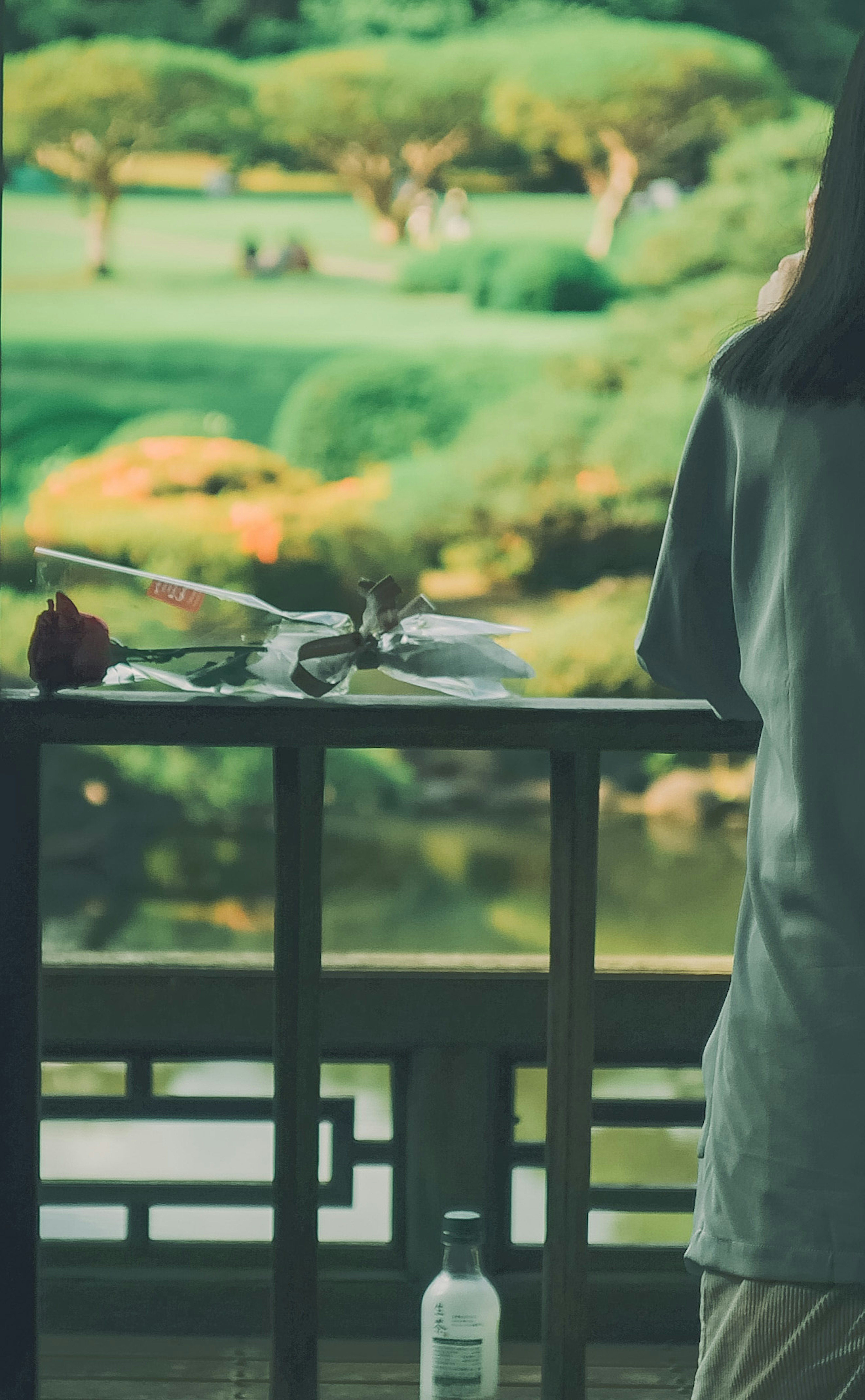 Un tavolo con un fiore e una bevanda che si affaccia su un bel giardino