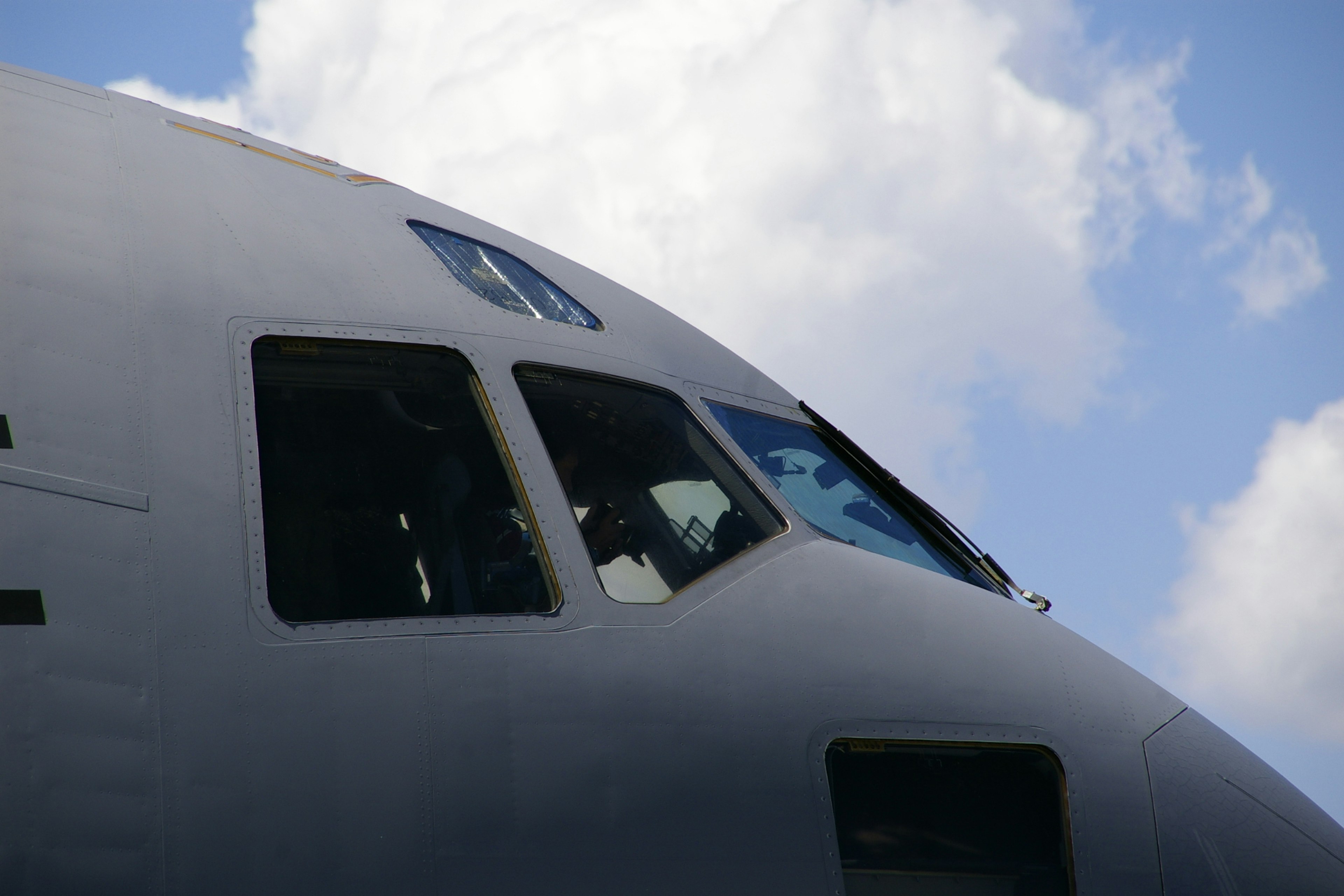 Close-up of an airplane cockpit with clouds in the background