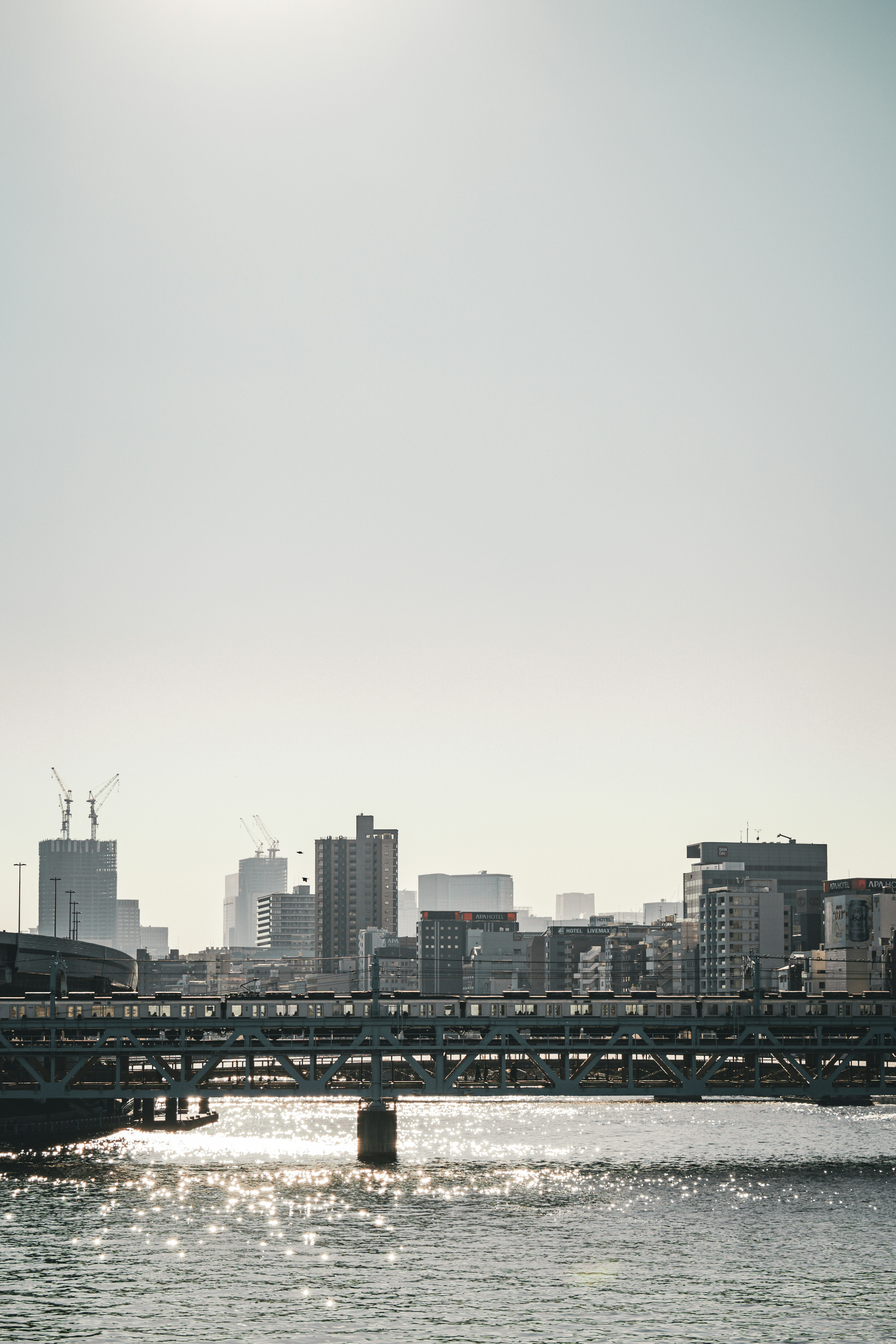 都市の風景と川の橋を背景にした明るい空