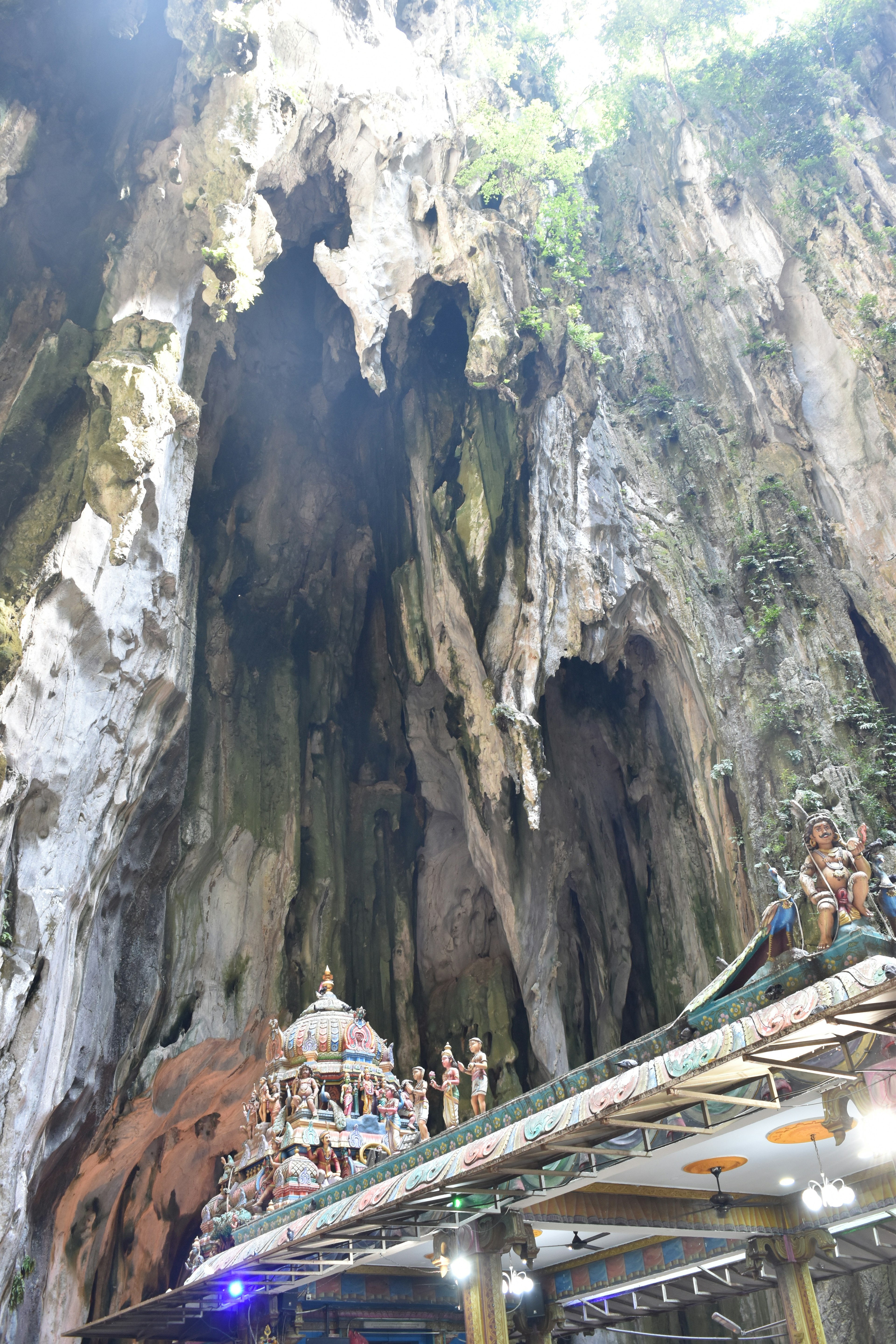 Interior of Batu Caves featuring a temple and majestic rock formations