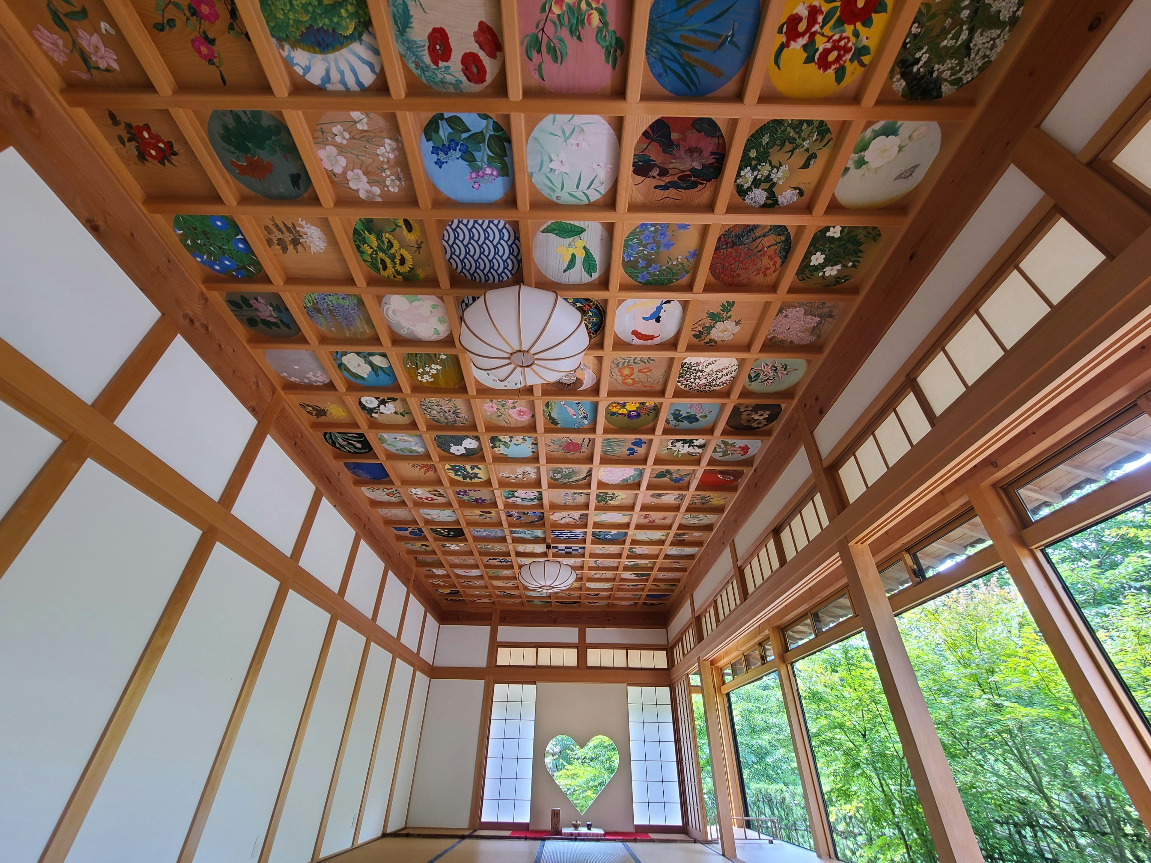 Schöner Decke mit bunten gerahmten Gemälden Holz Wände und natürliches Licht, das durch die Fenster strömt