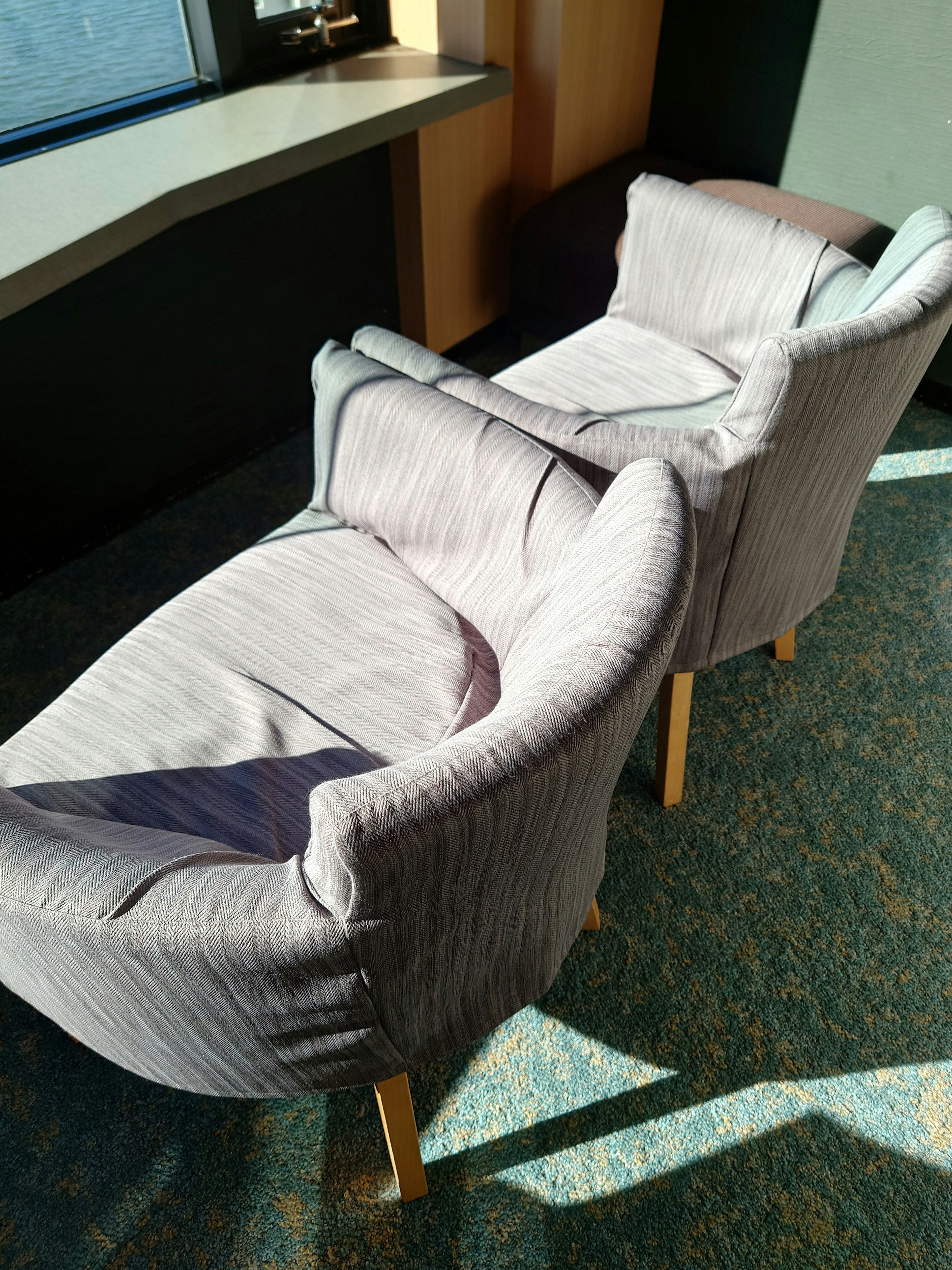 Two gray armchairs placed by a bright window