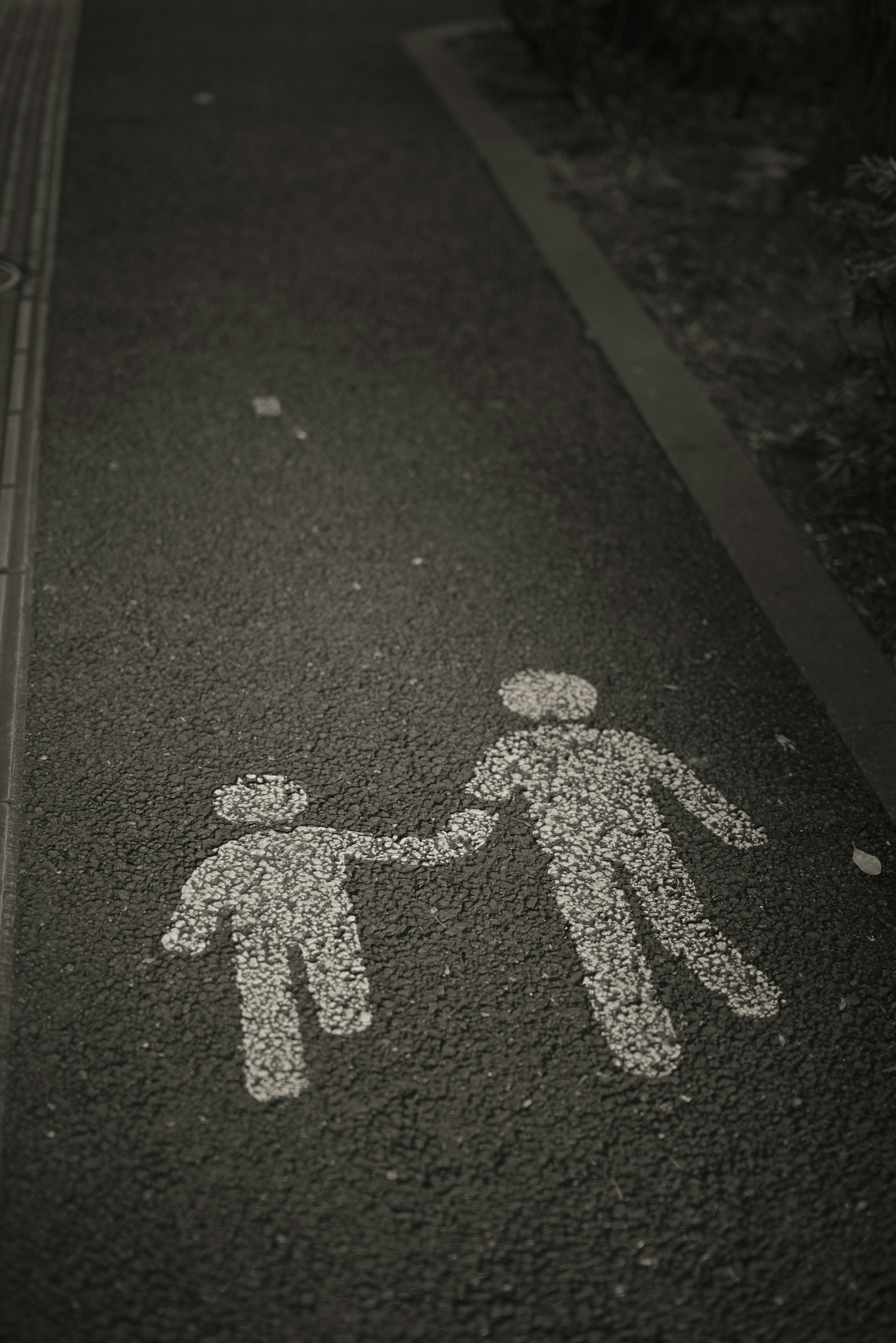 Peinture sur trottoir d'un adulte et d'un enfant se tenant la main