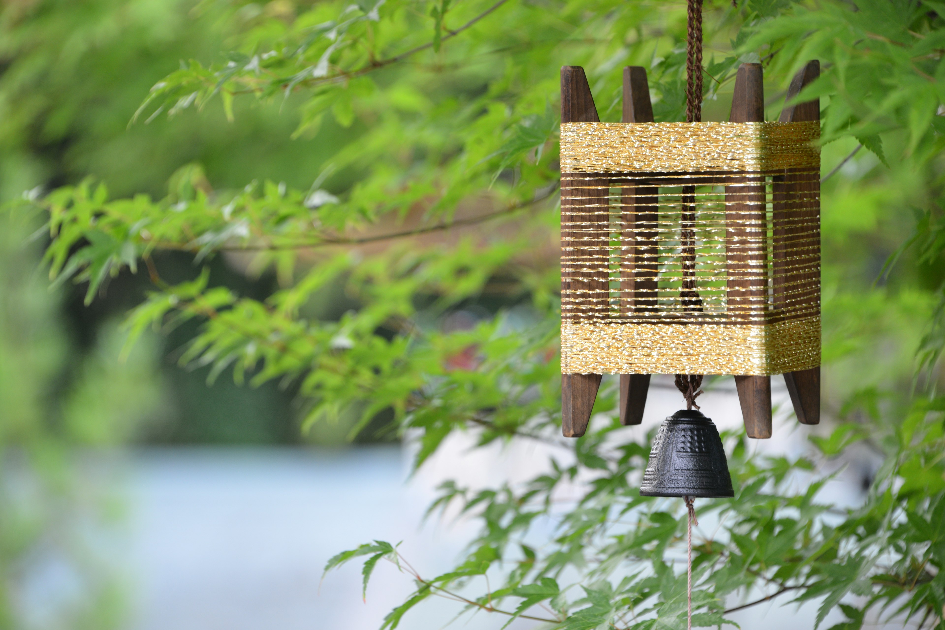 Beautiful wind chime lantern surrounded by green leaves