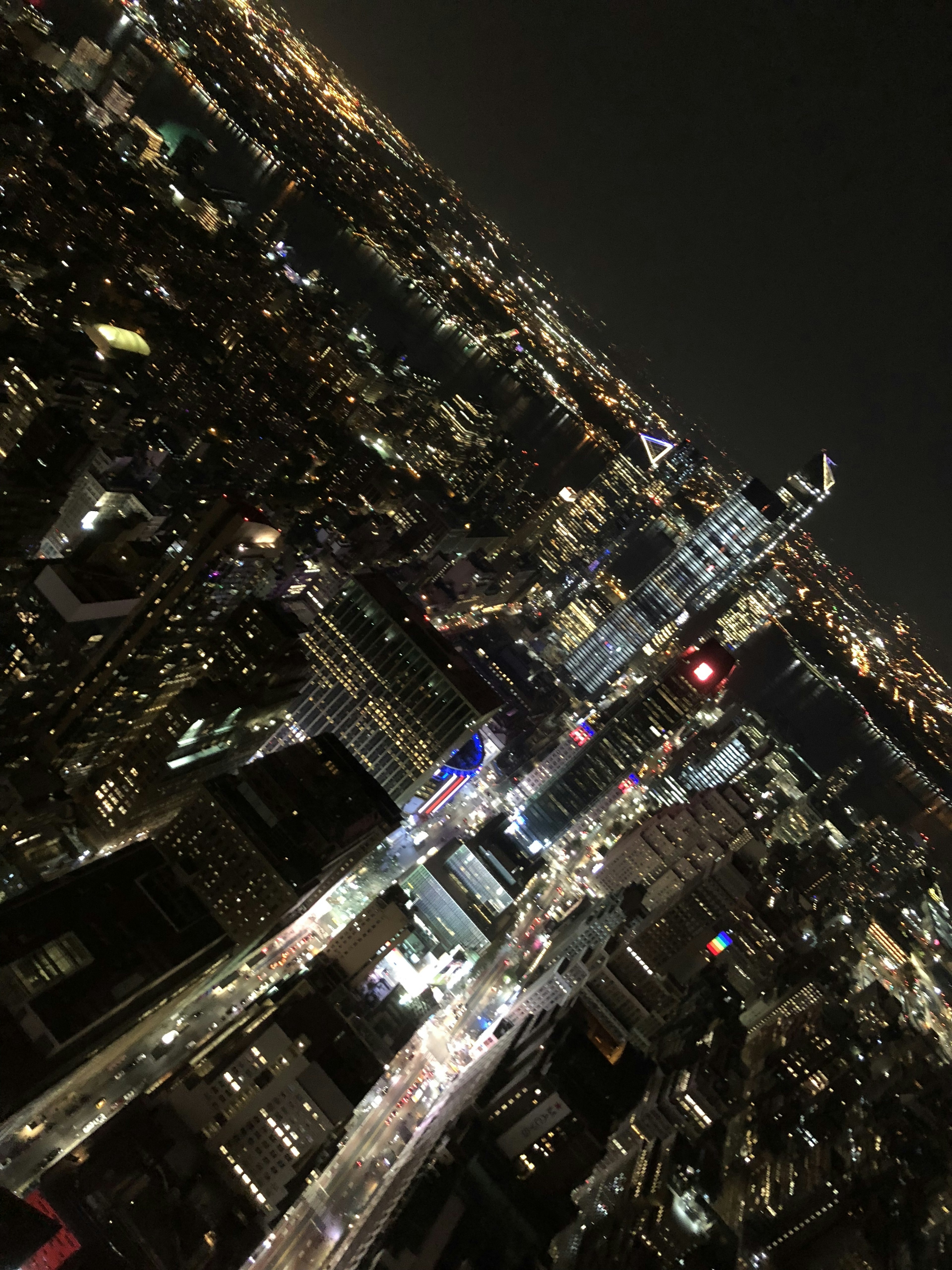 Vista aérea de un horizonte urbano de noche con edificios iluminados y calles