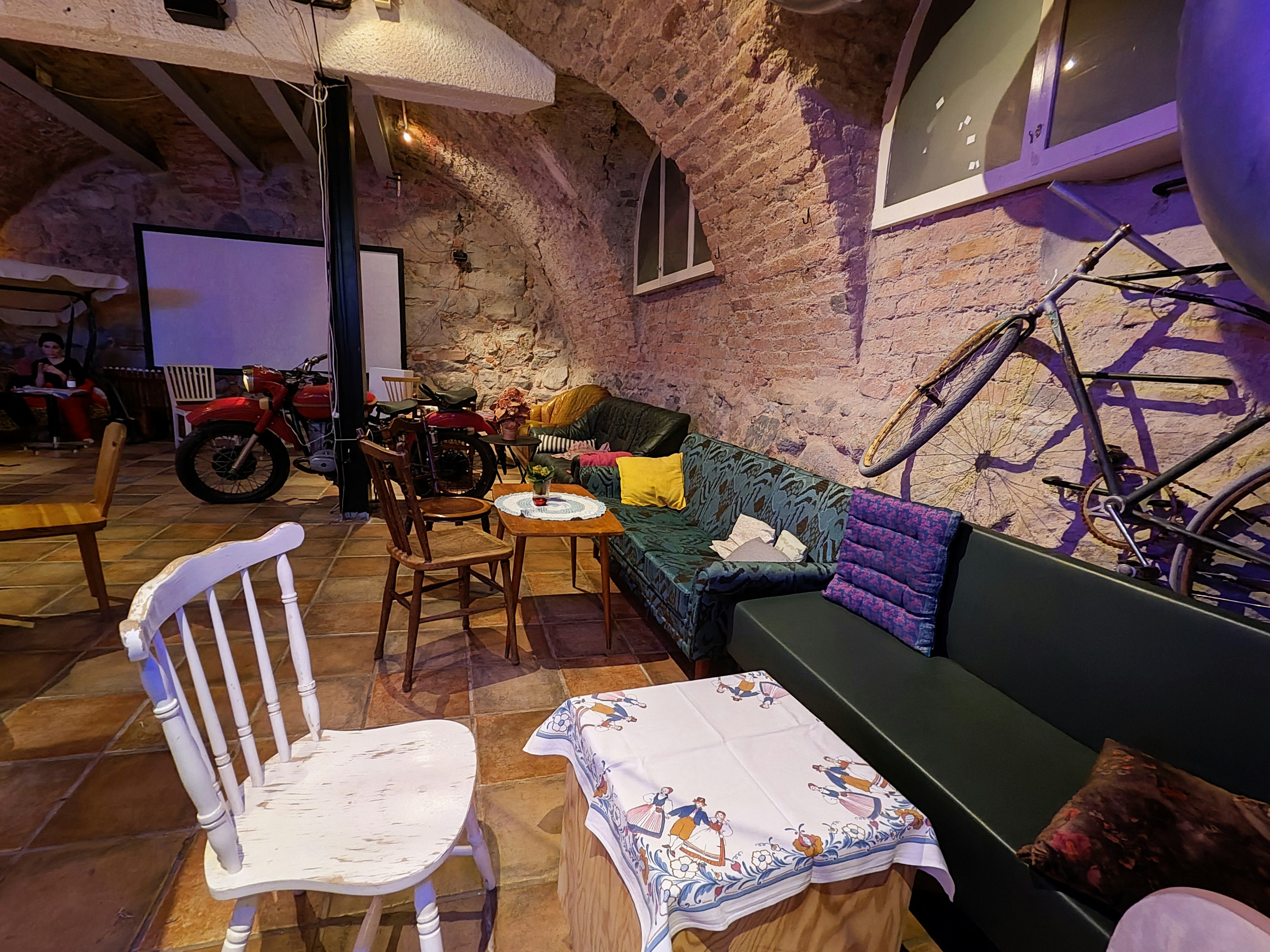 Cozy café-like space with an arched ceiling featuring motorcycles and bicycles