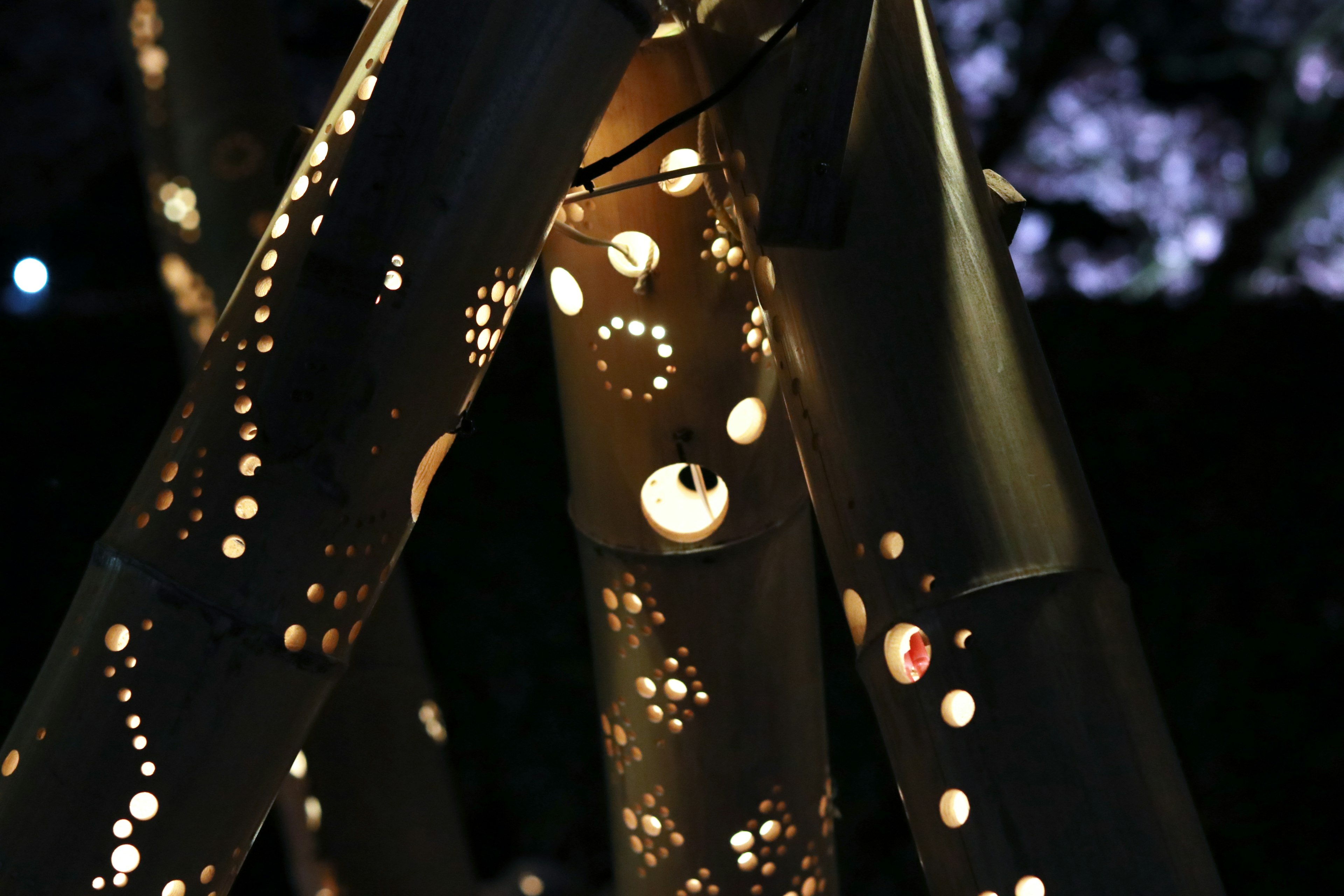 Close-up of a bamboo structure with holes allowing light to shine through