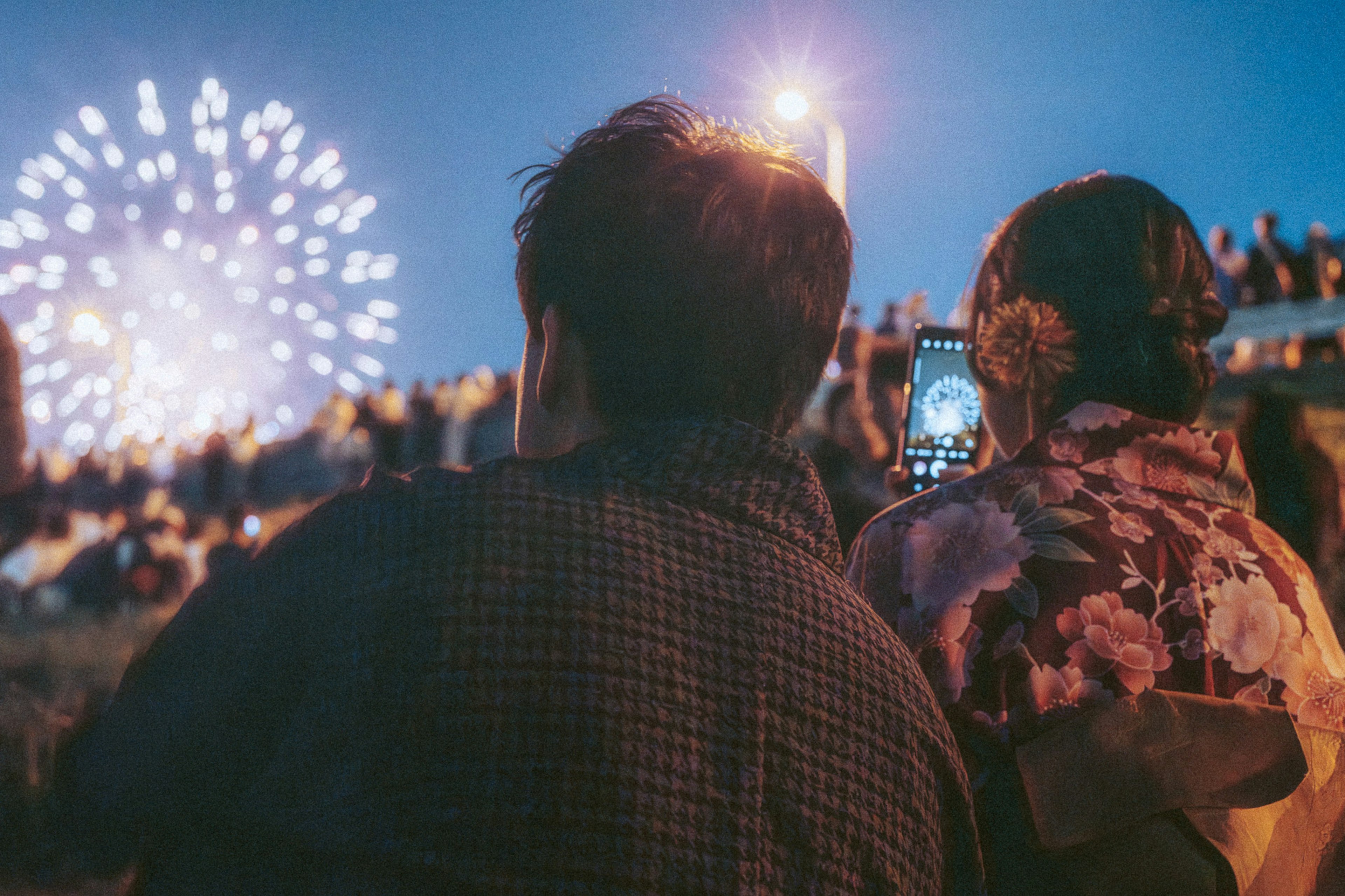 Pareja viendo fuegos artificiales contra un cielo nocturno