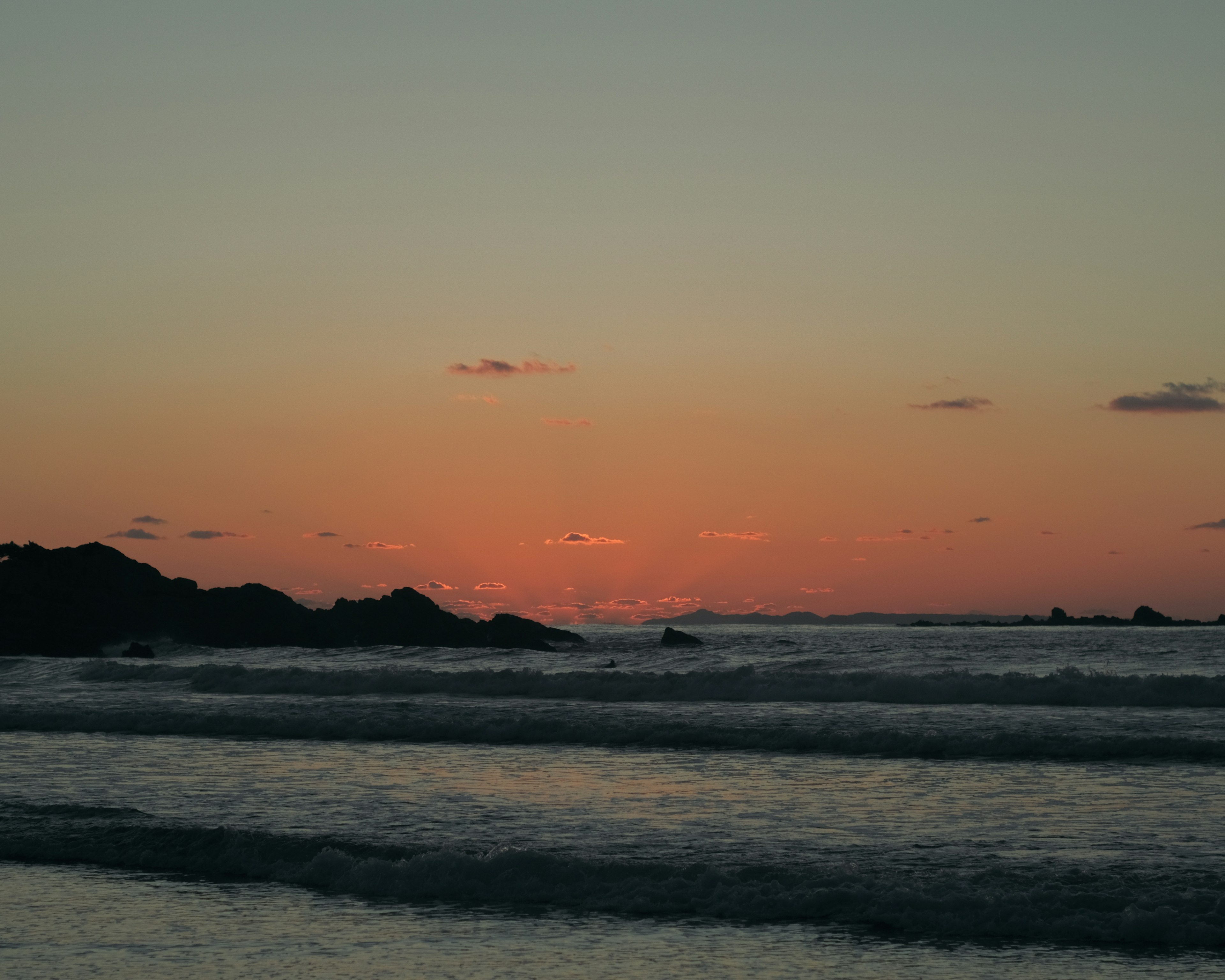 Vue panoramique d'un coucher de soleil sur l'océan avec des vagues douces