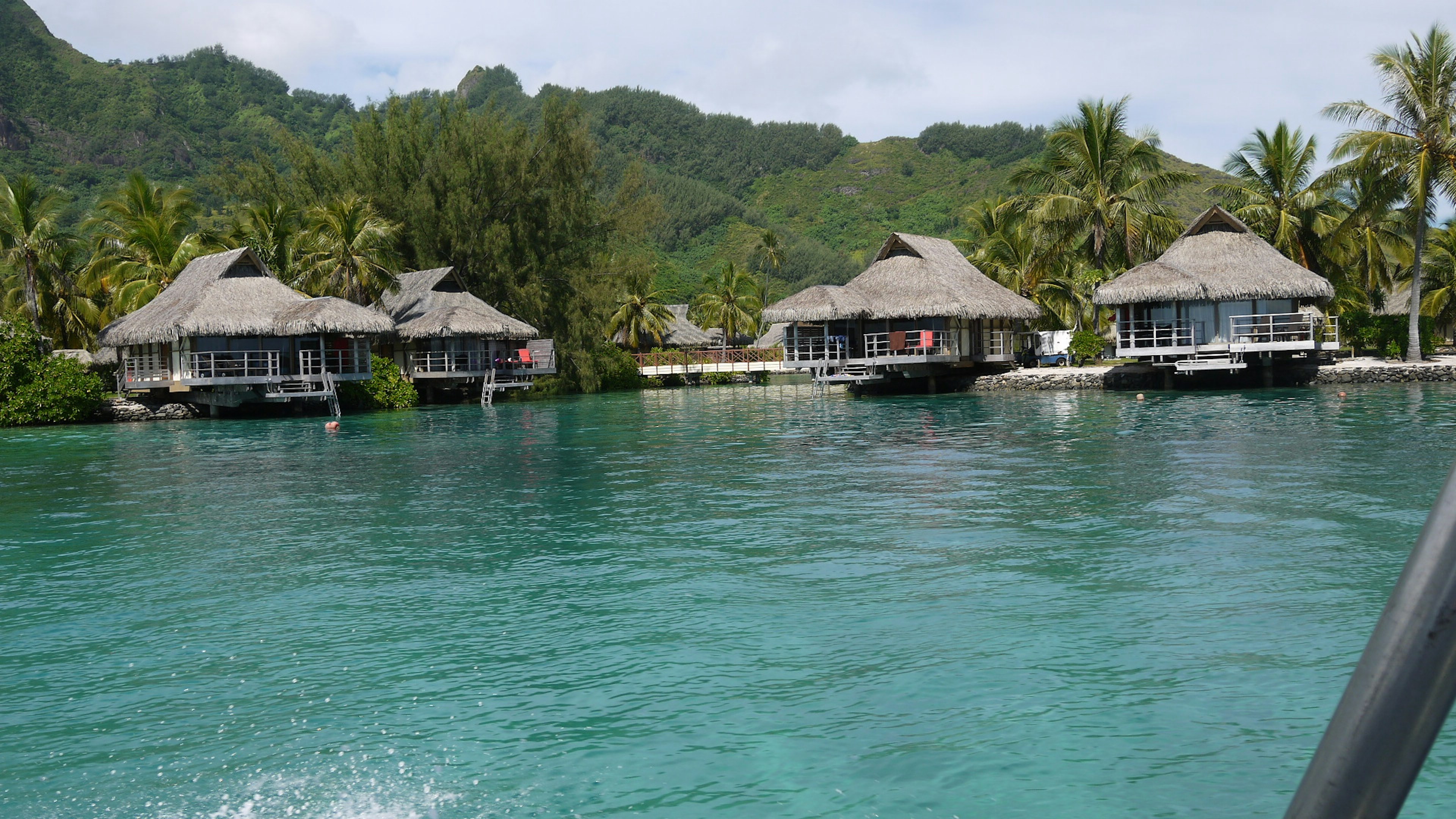 Tropische Landschaft mit schönen Wasserbungalows und üppigen grünen Bergen