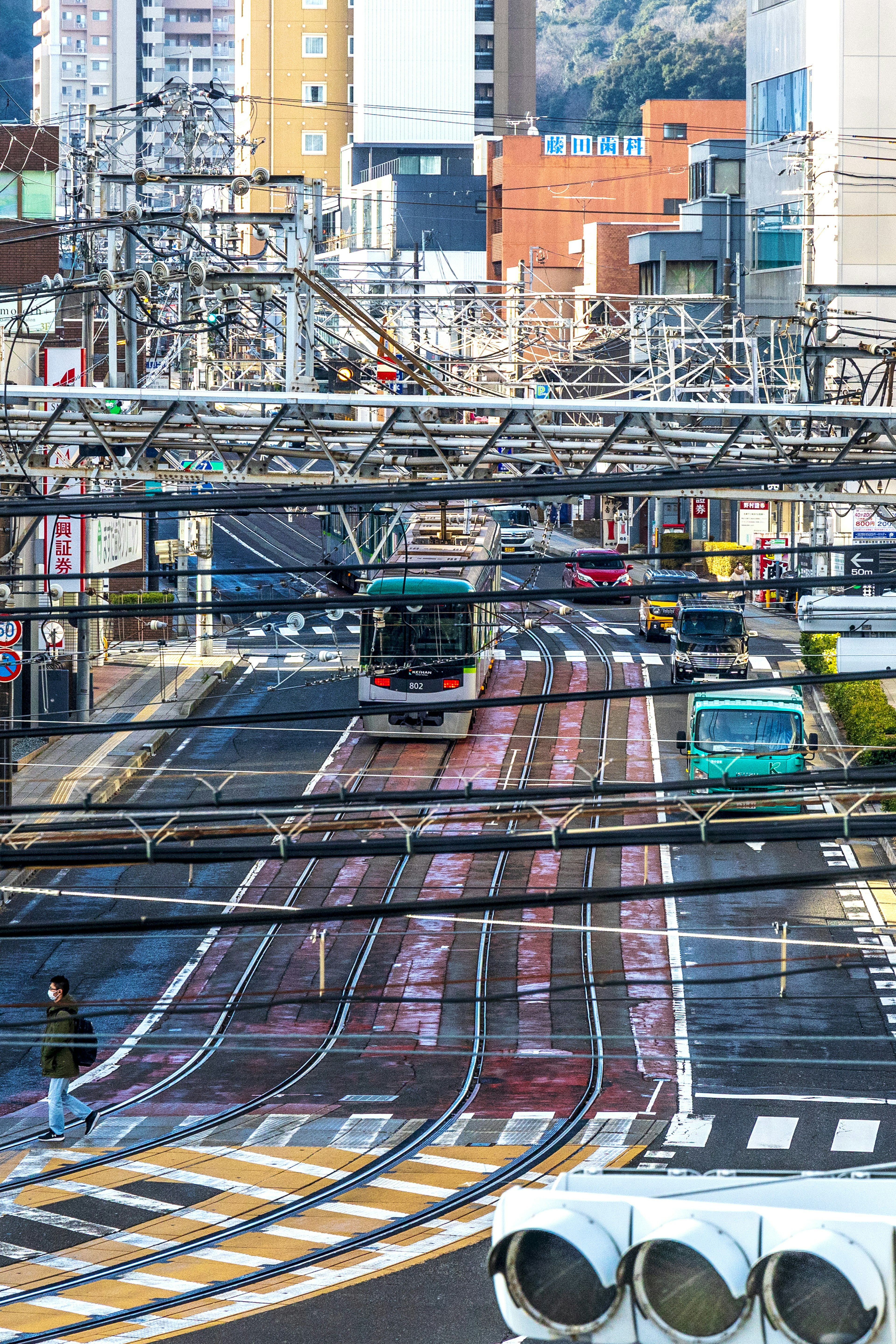 Scena urbana con incrocio tra ferrovia e strada con autobus e treni