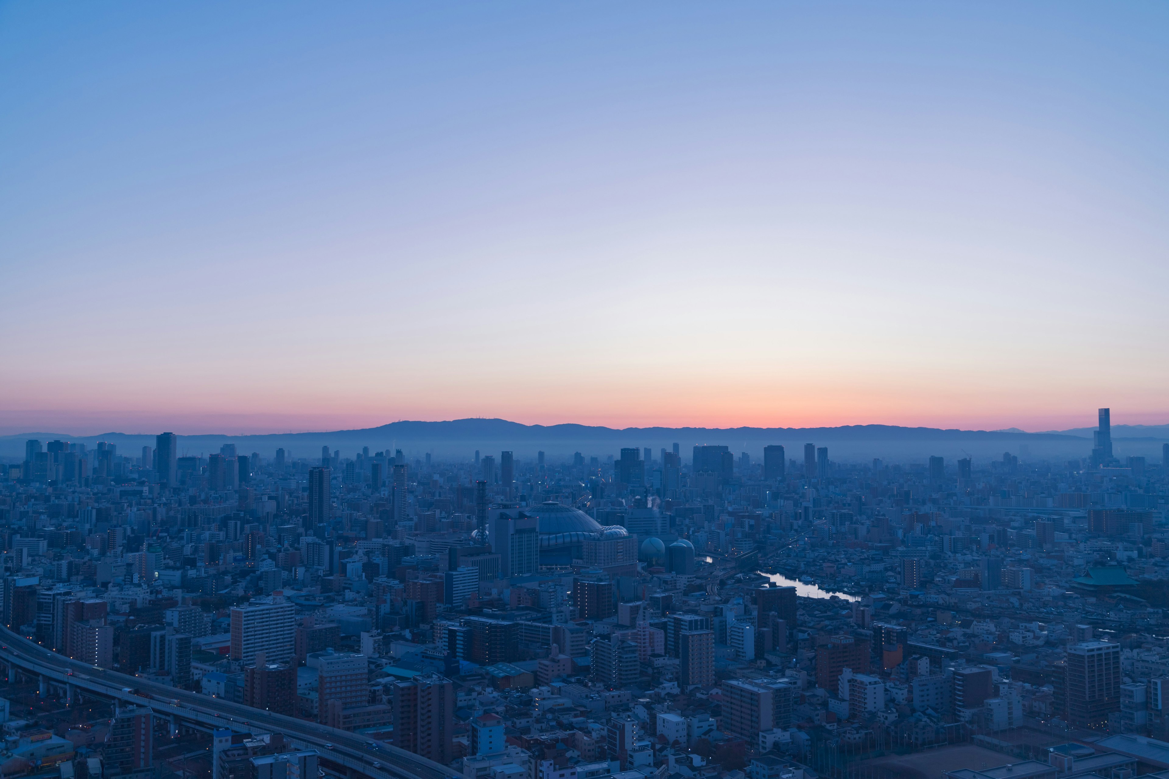 Orizzonte dell'alba di una città cielo blu con luce soffusa e montagne lontane