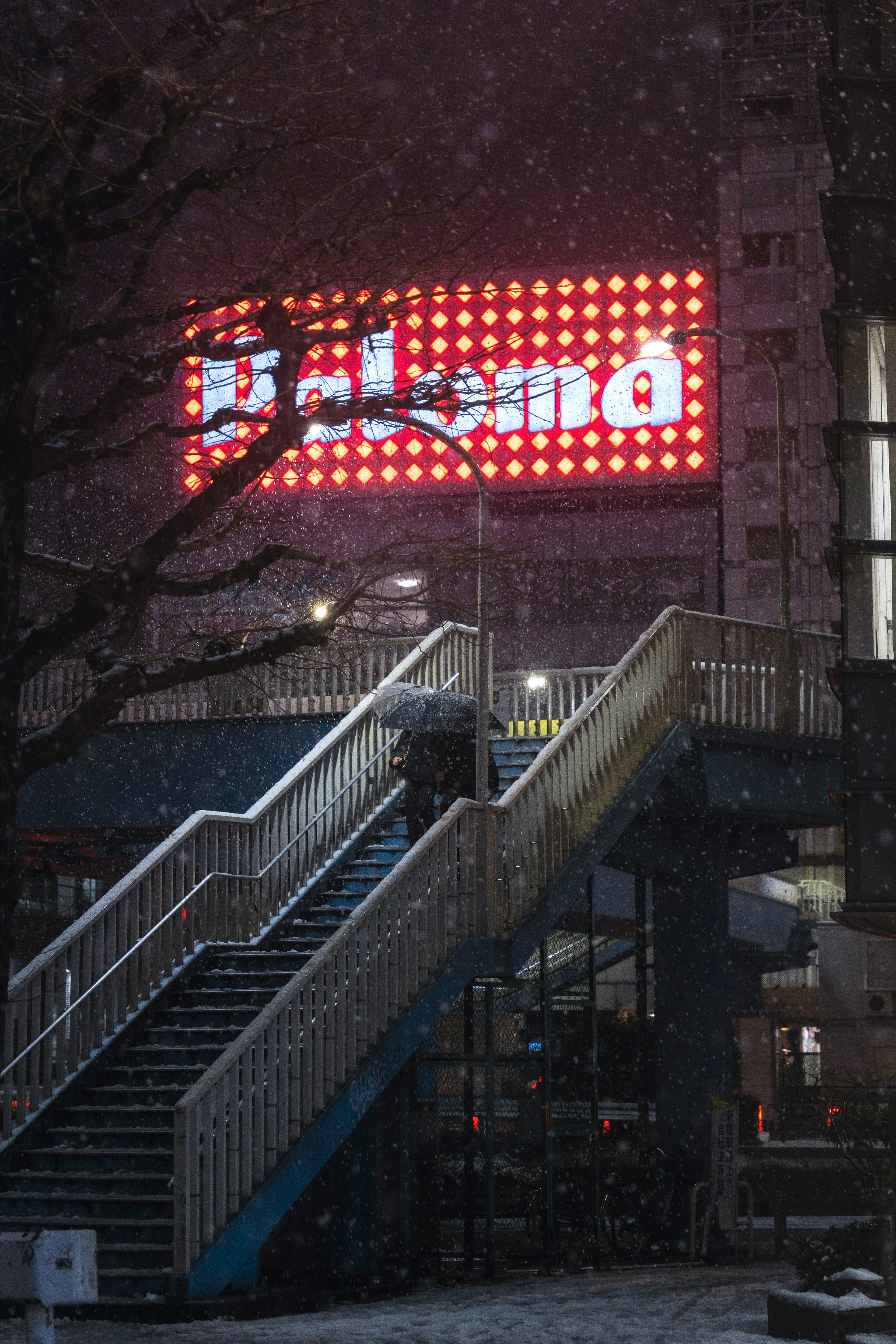 階段と明るい看板がある都市の風景