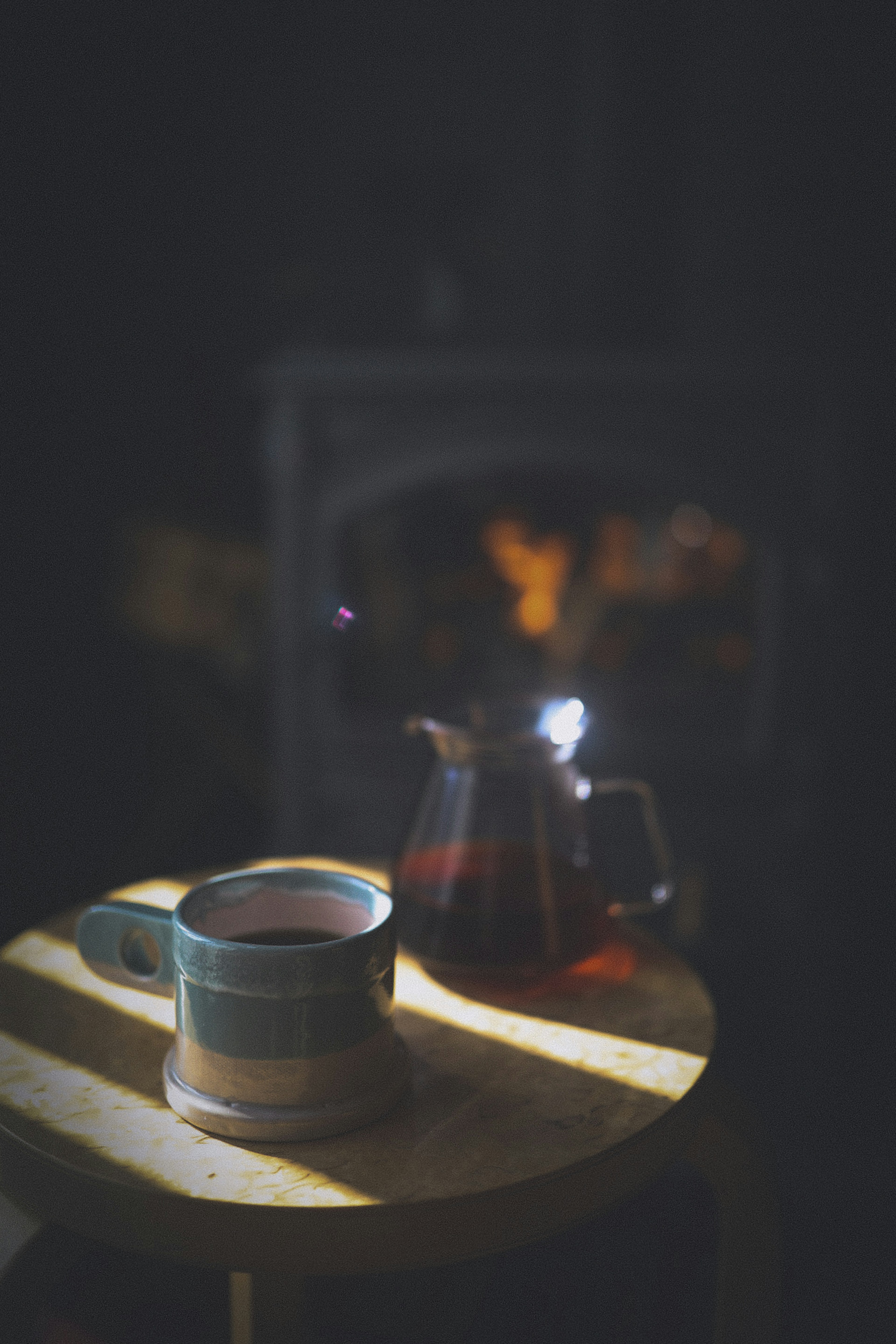 Une tasse de café et une théière sur une table en bois avec un éclairage chaleureux