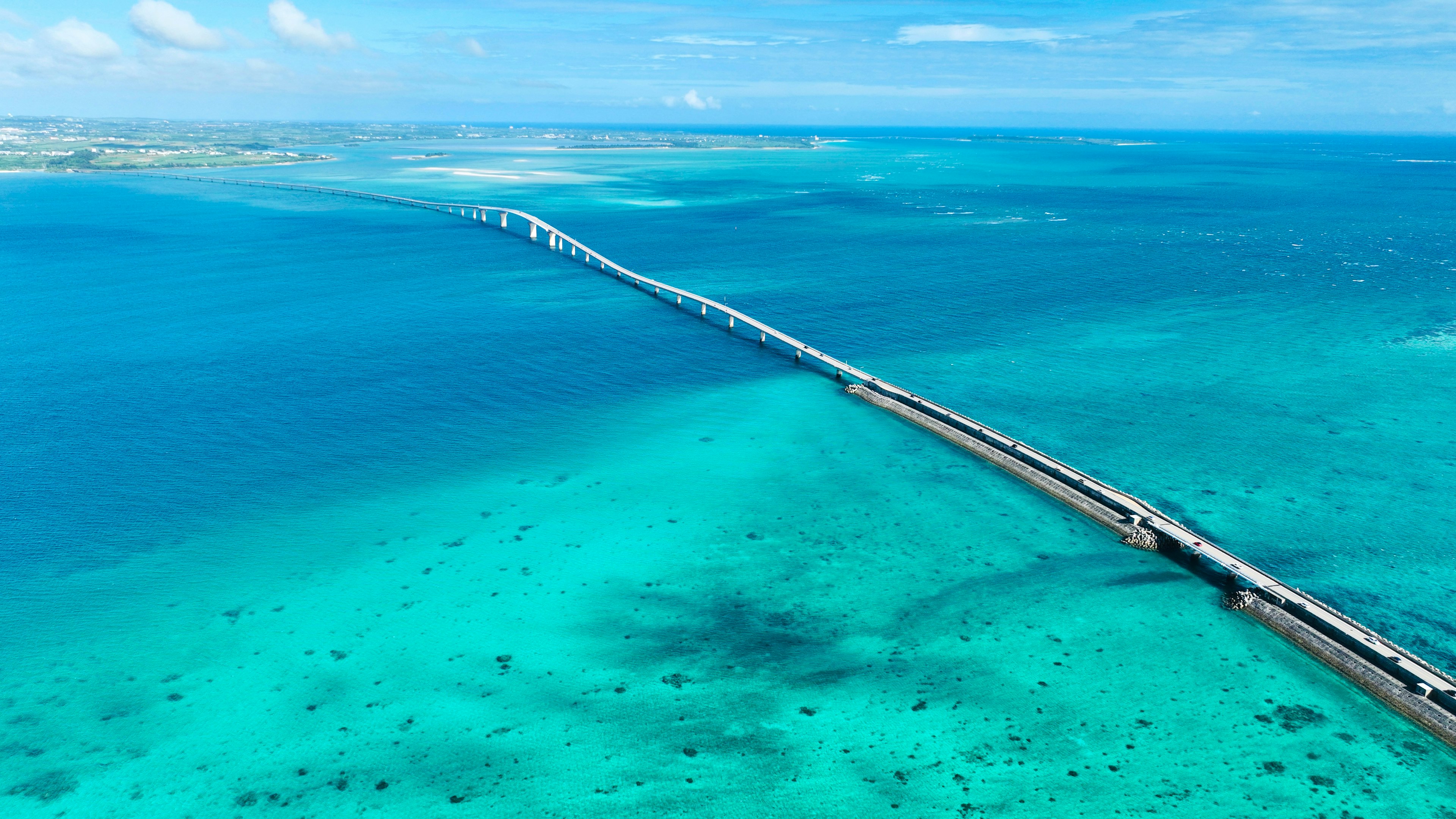 Pemandangan udara laut turquoise dengan jembatan panjang yang membentang melintasinya