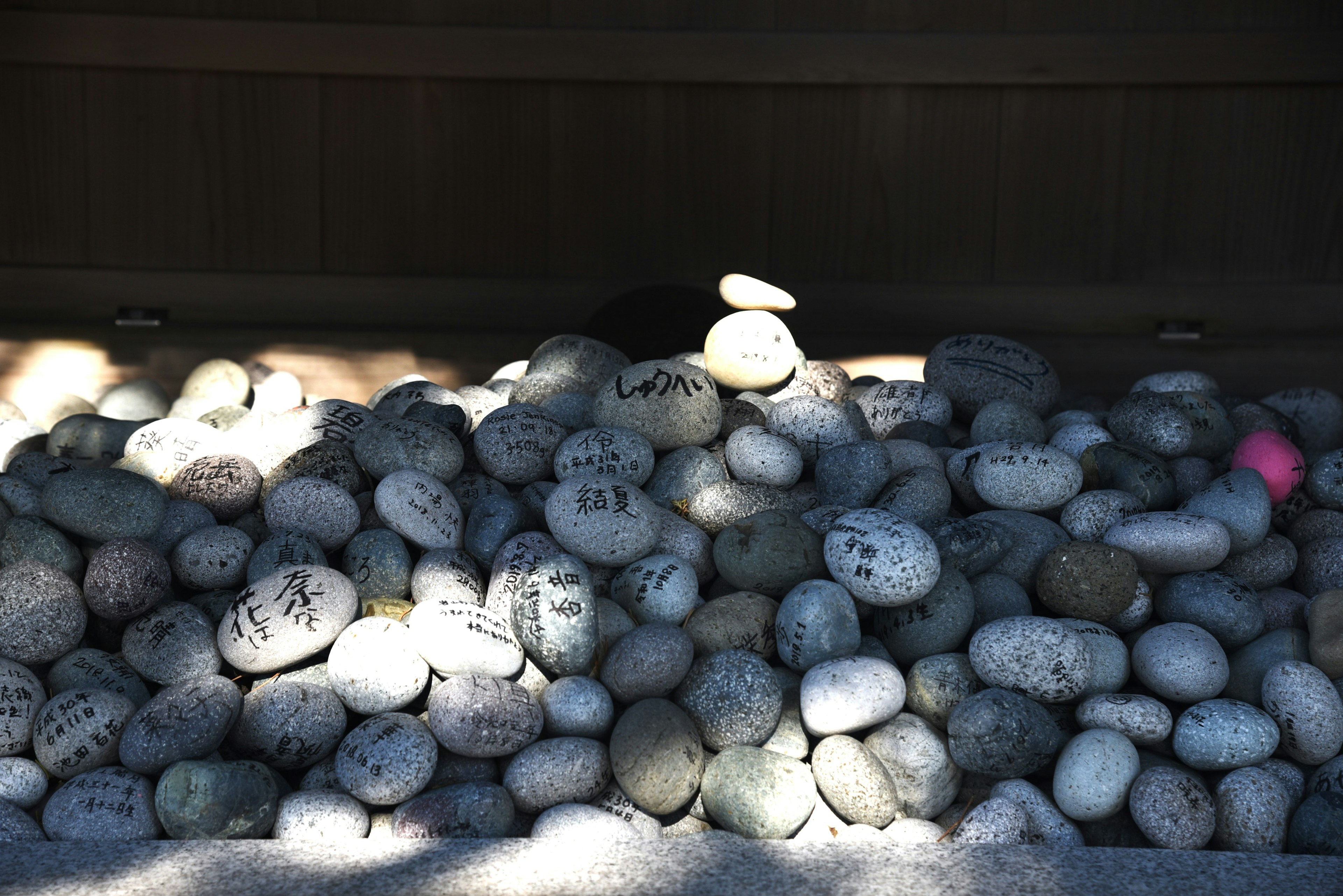 A pile of variously colored and shaped stones with contrasting light and shadow