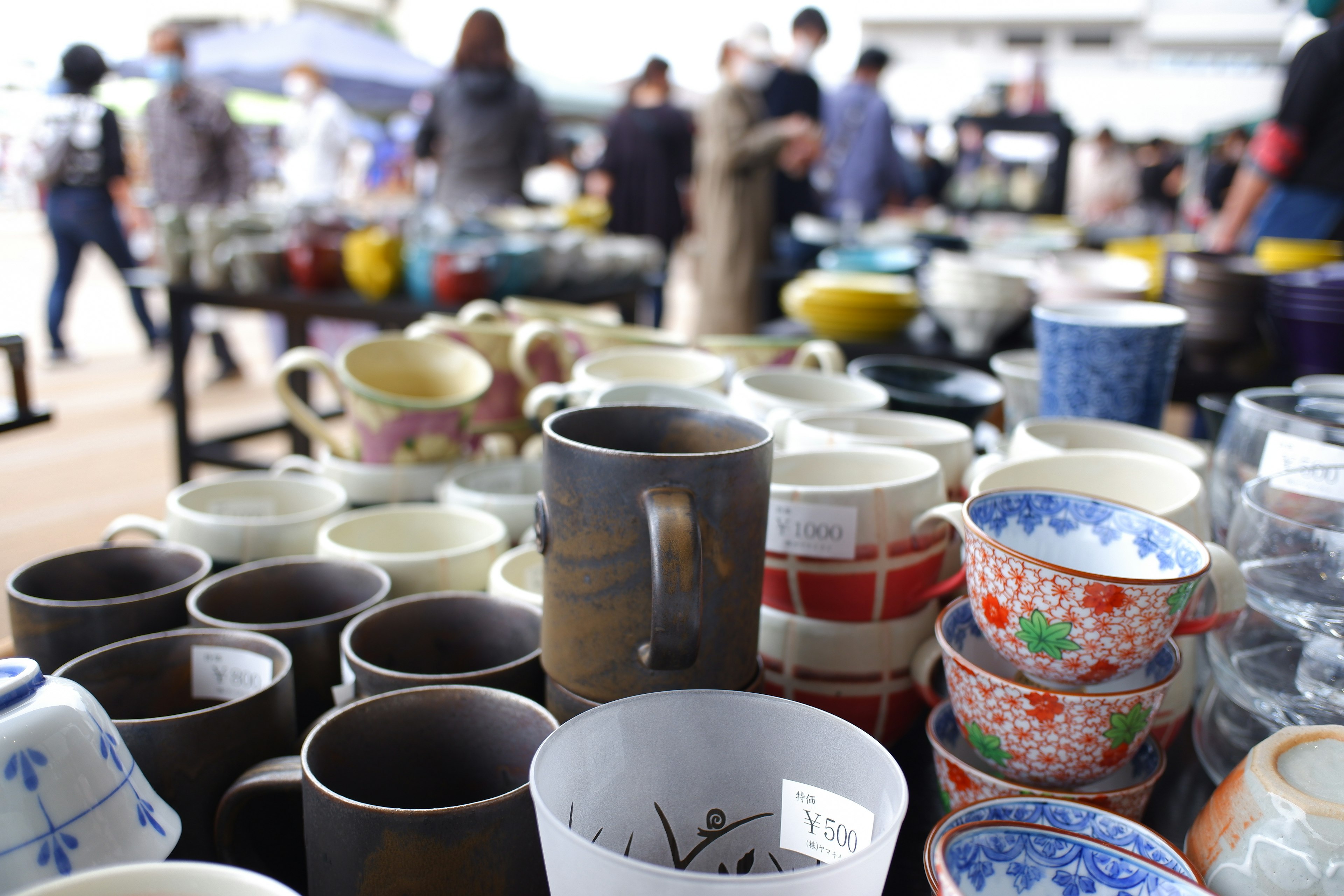 Bunte Keramiktassen und -teller auf einem Markt ausgestellt