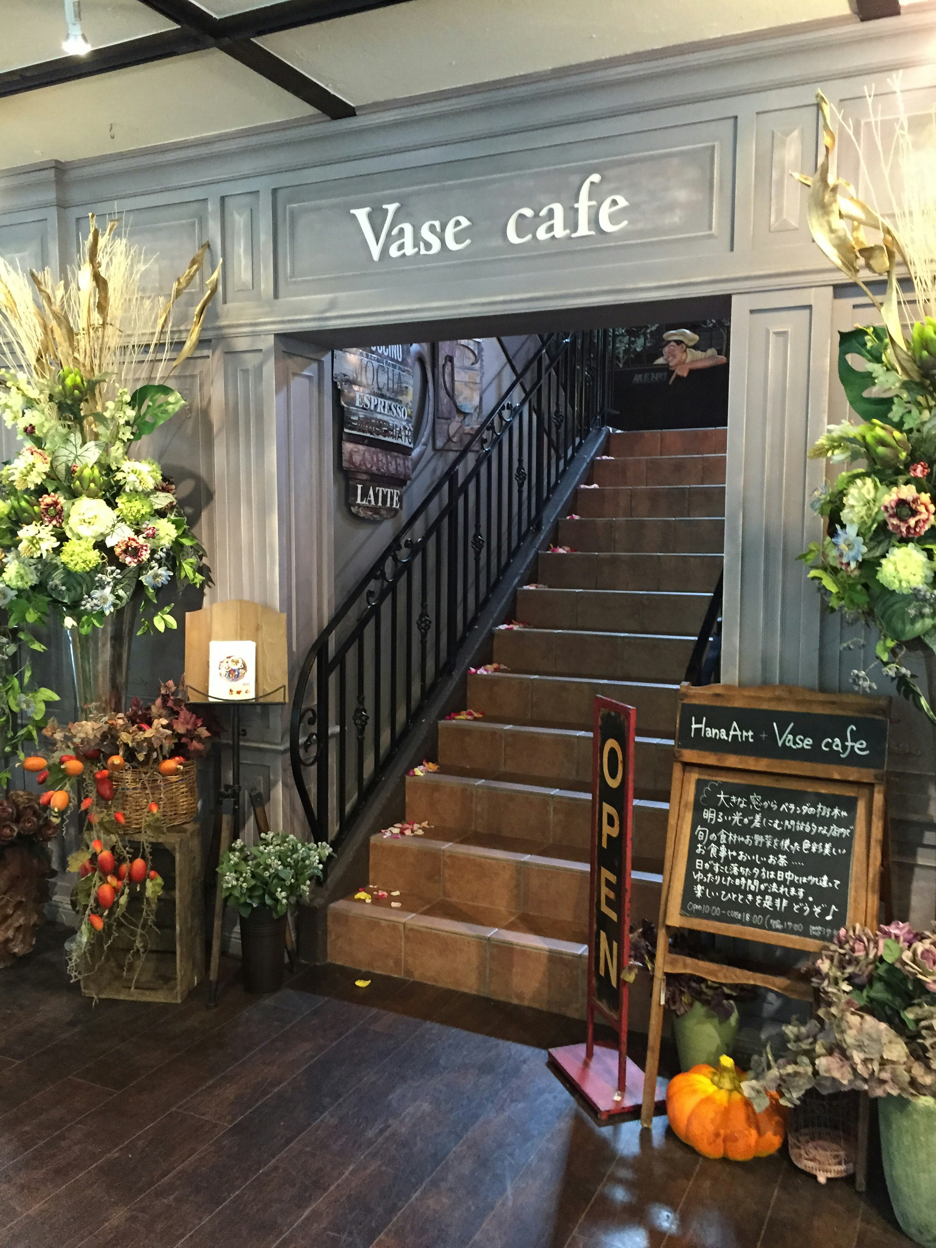 Entrée du Vase cafe avec escaliers et décorations florales