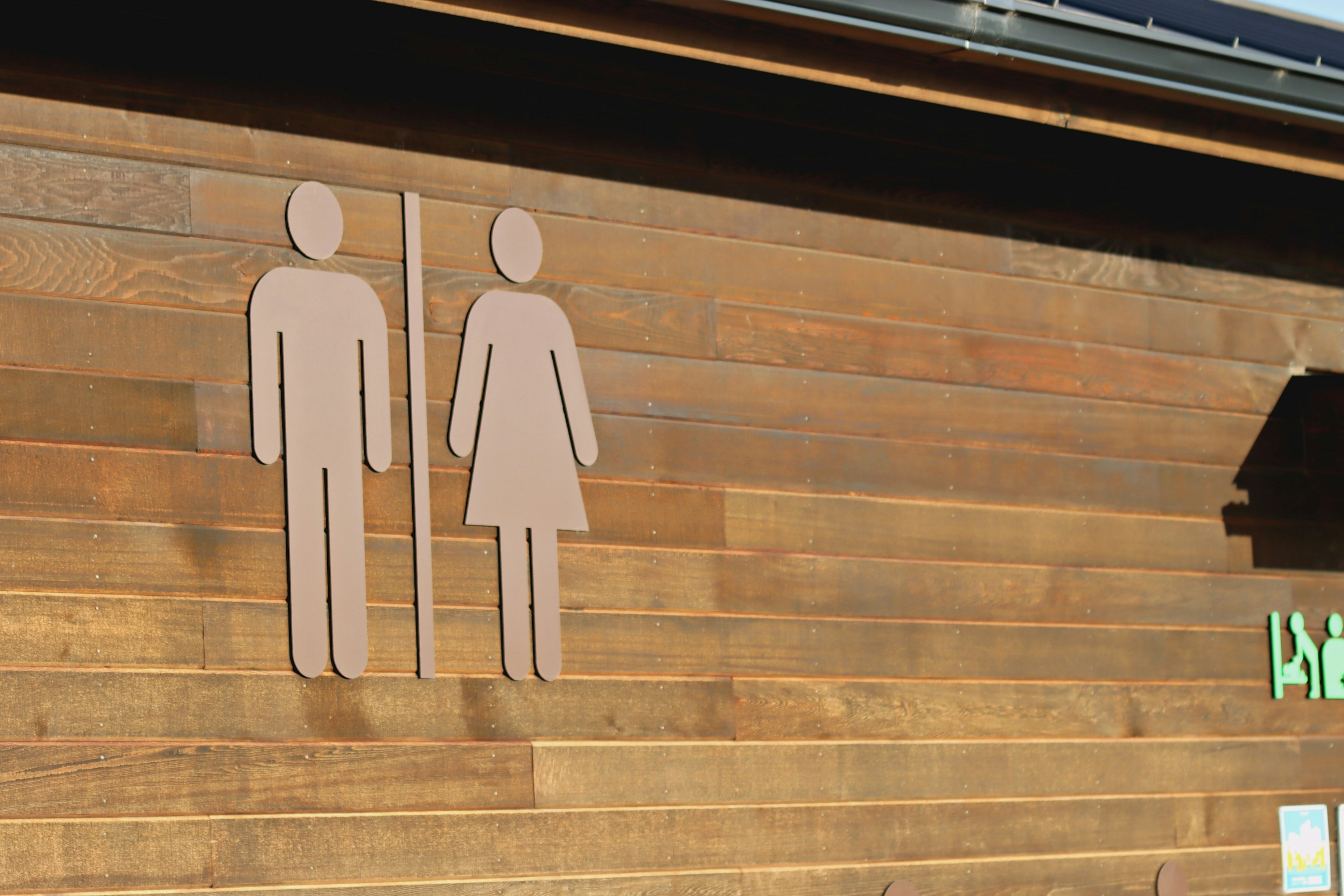 Restroom signs for men and women on a wooden wall