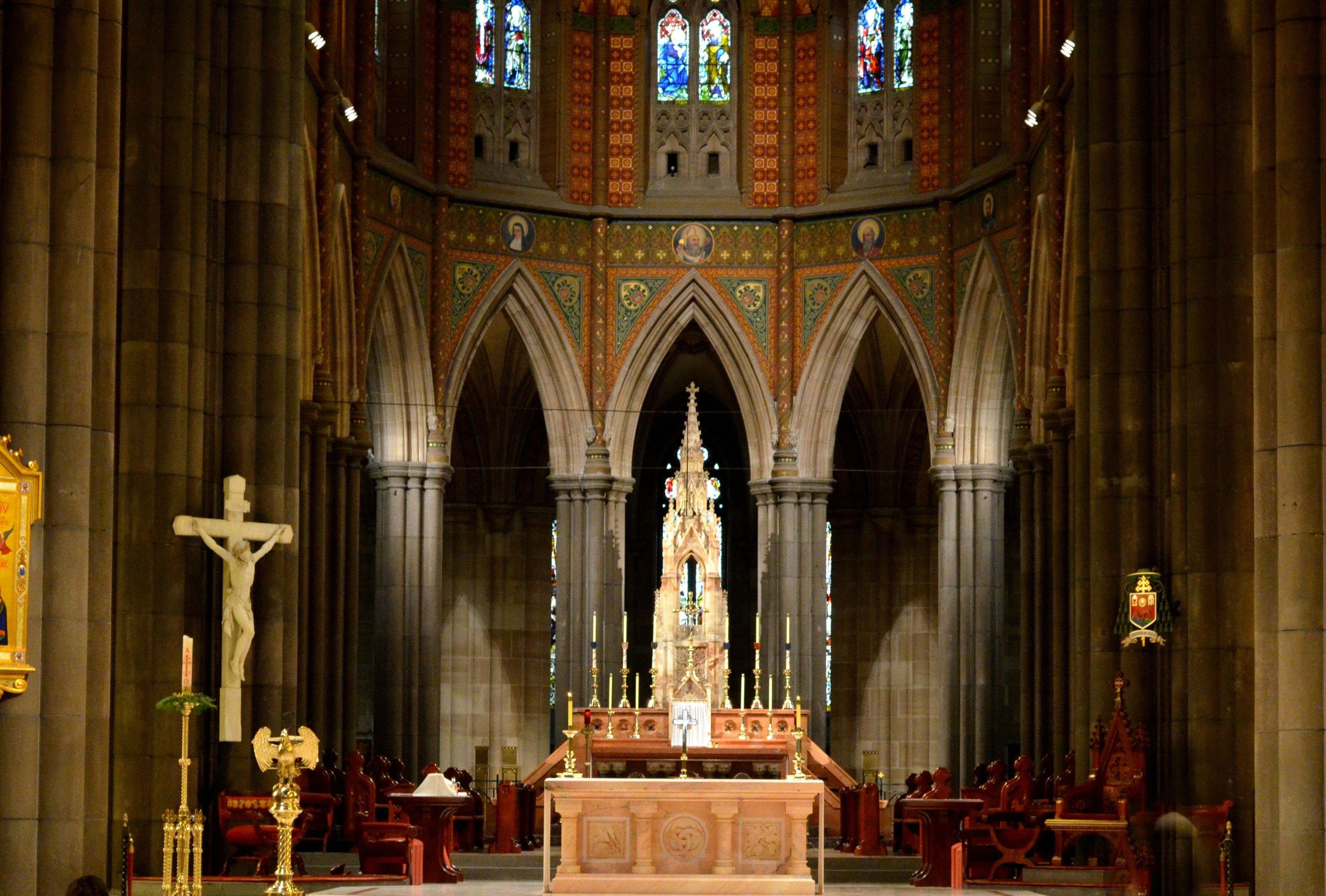 Interior of a cathedral featuring an altar and a prominent statue