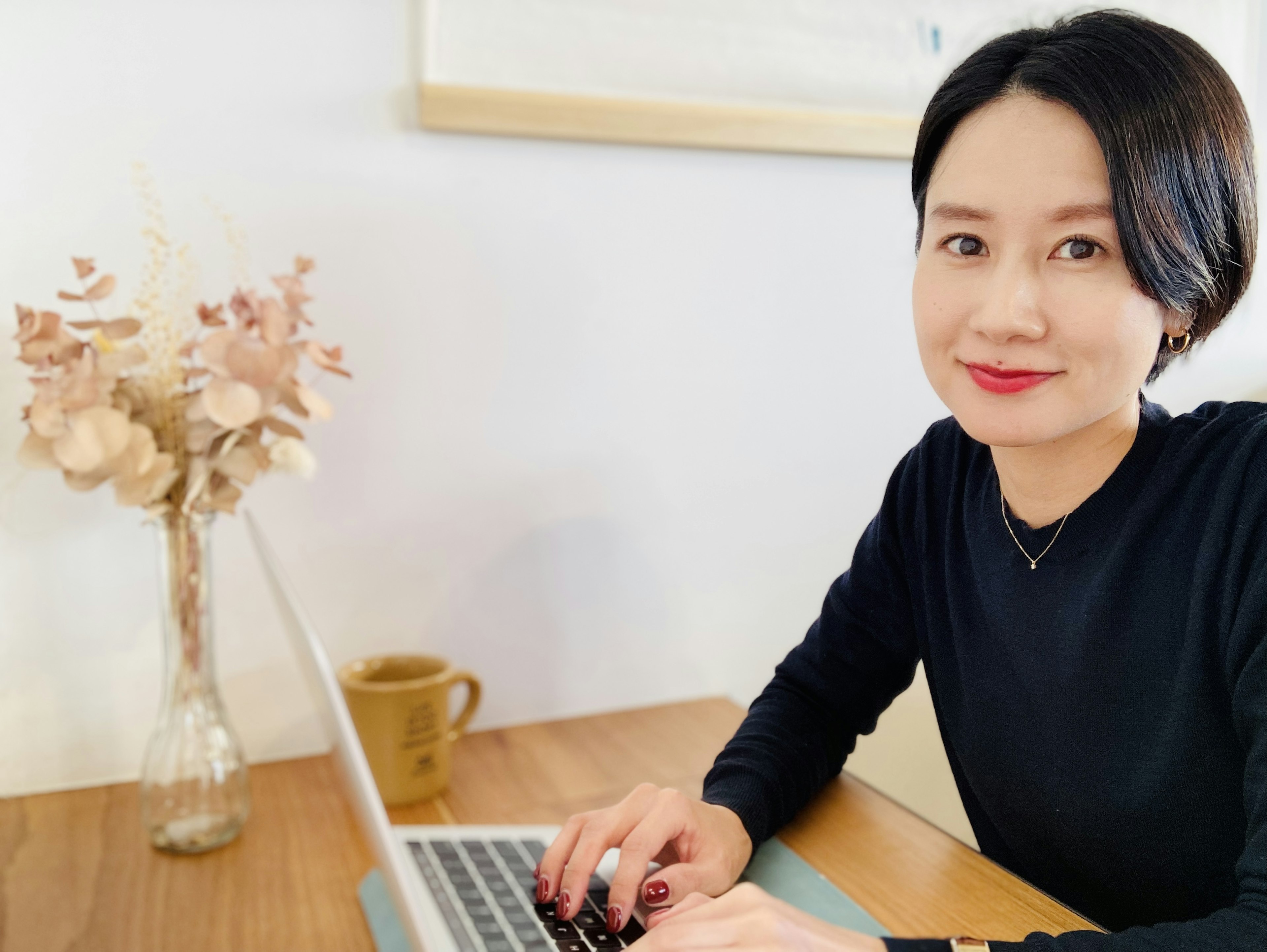 Woman working on a laptop in a cozy indoor setting