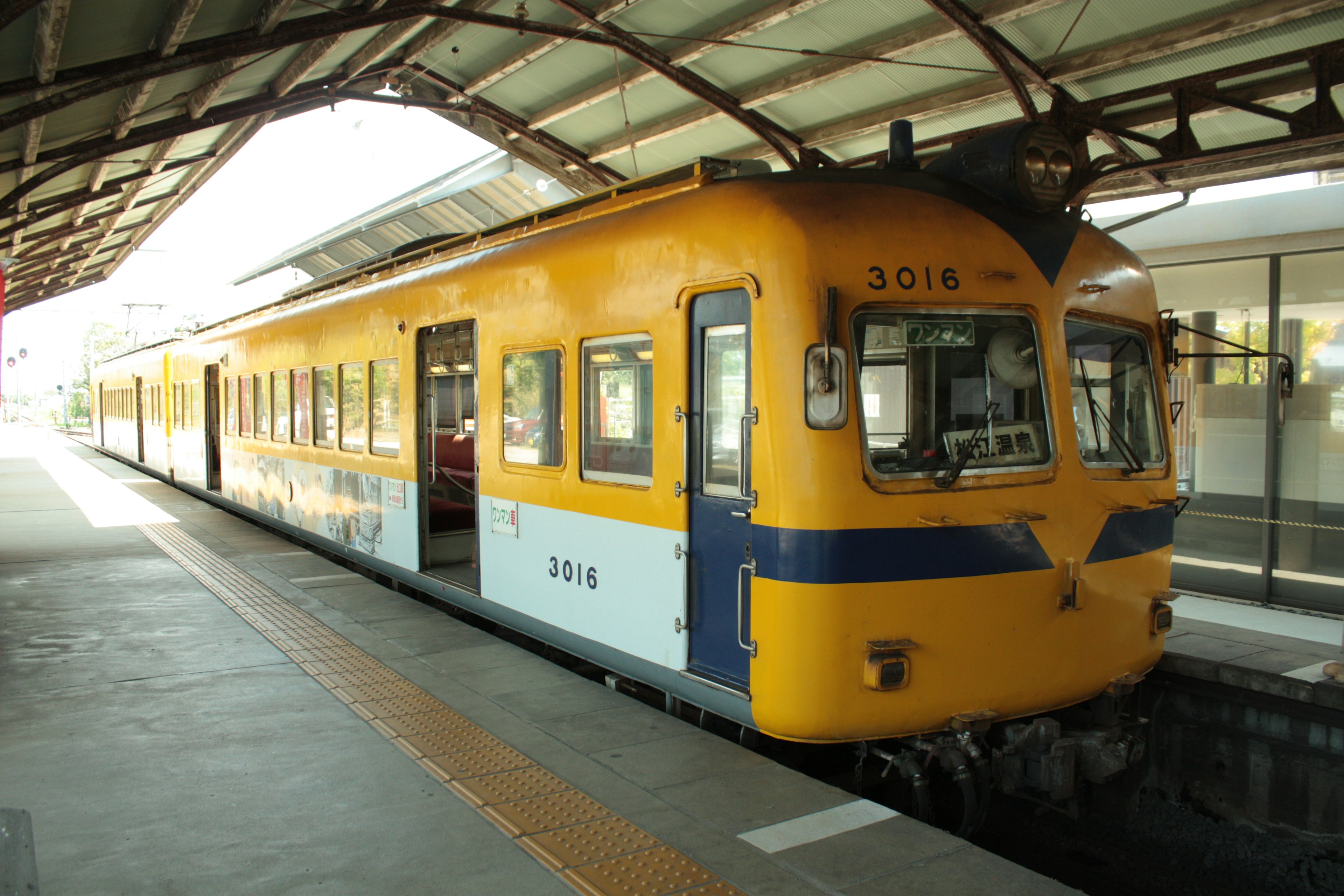 Kereta kuning dan biru diparkir di stasiun