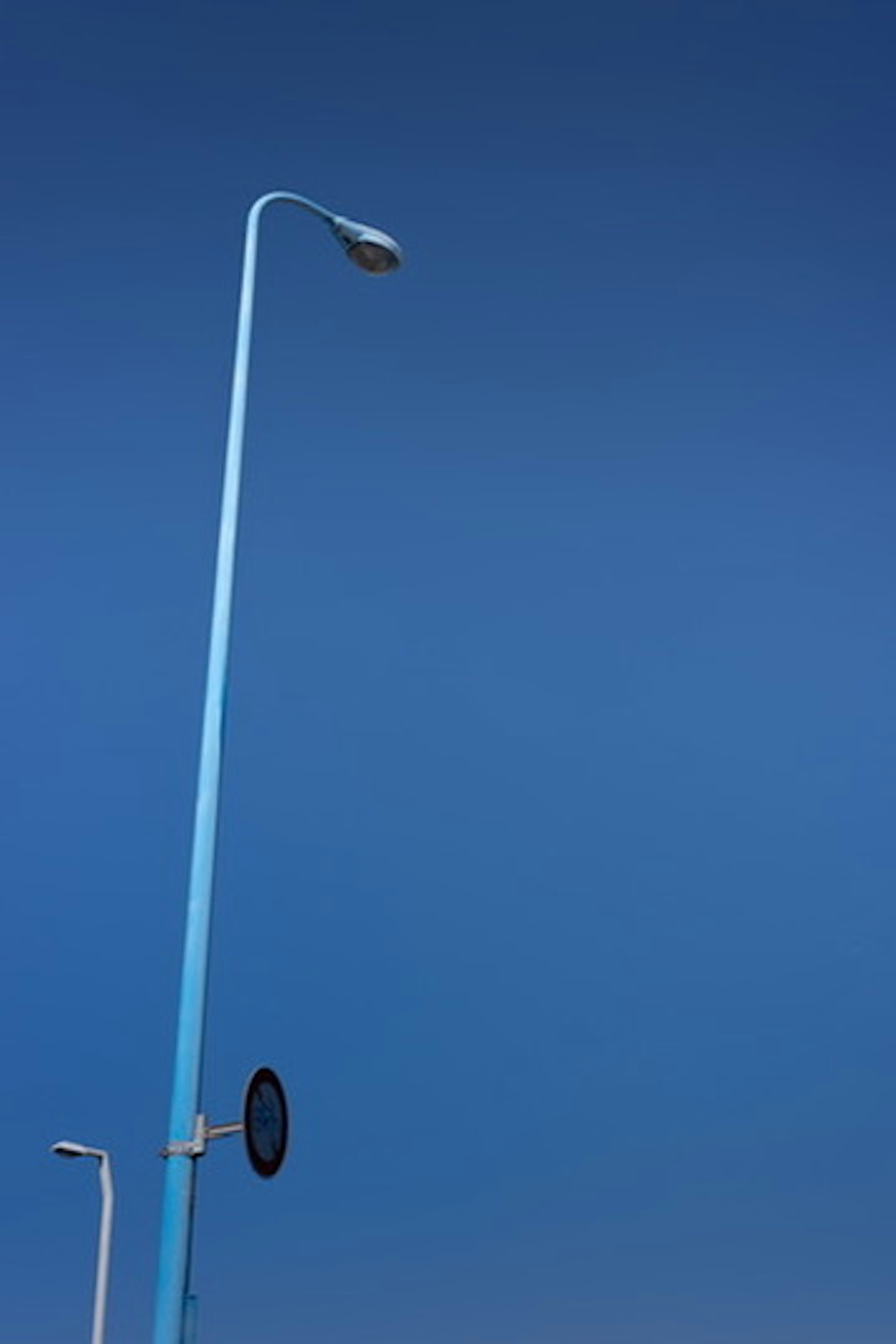 Un lampadaire bleu se dressant contre un ciel bleu clair