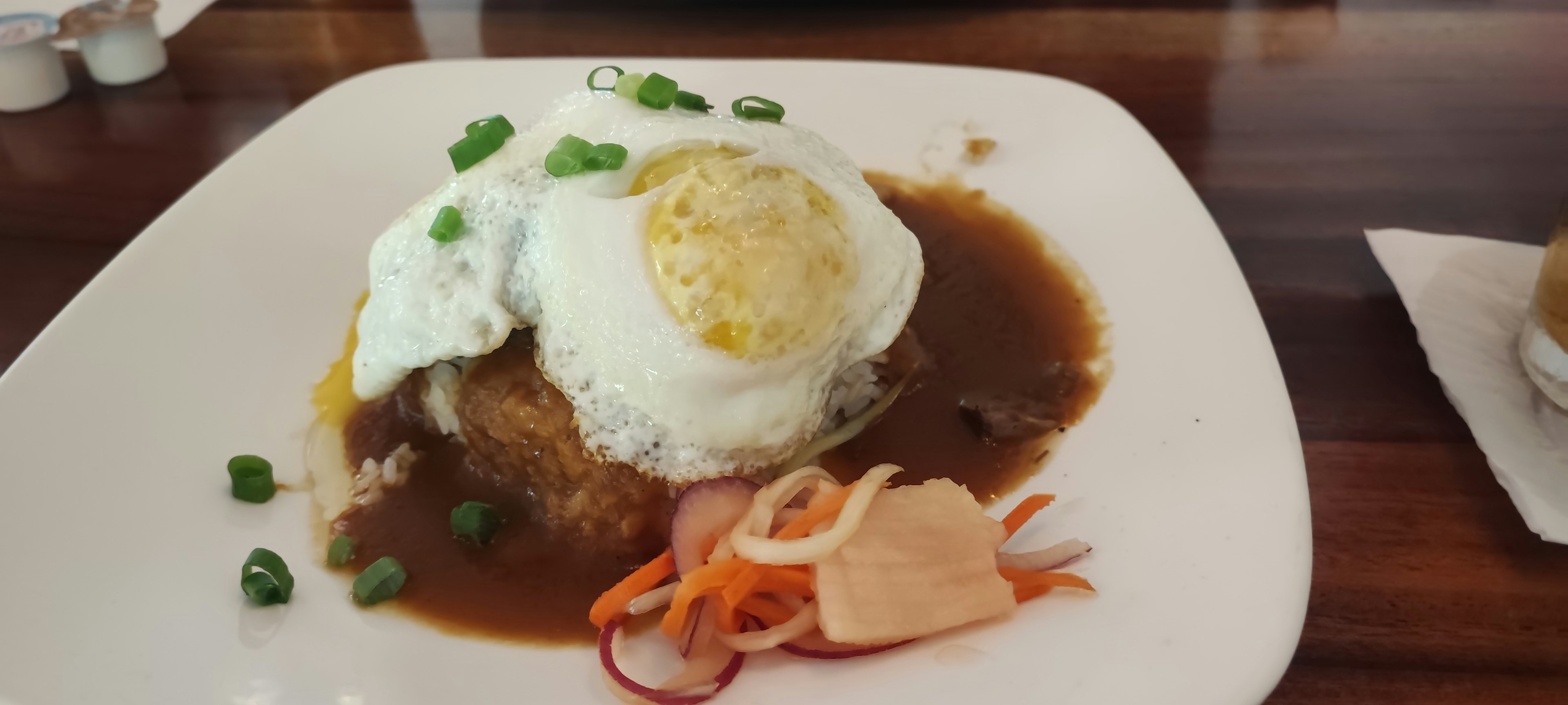 ご飯の上に目玉焼きとソースがかかった料理