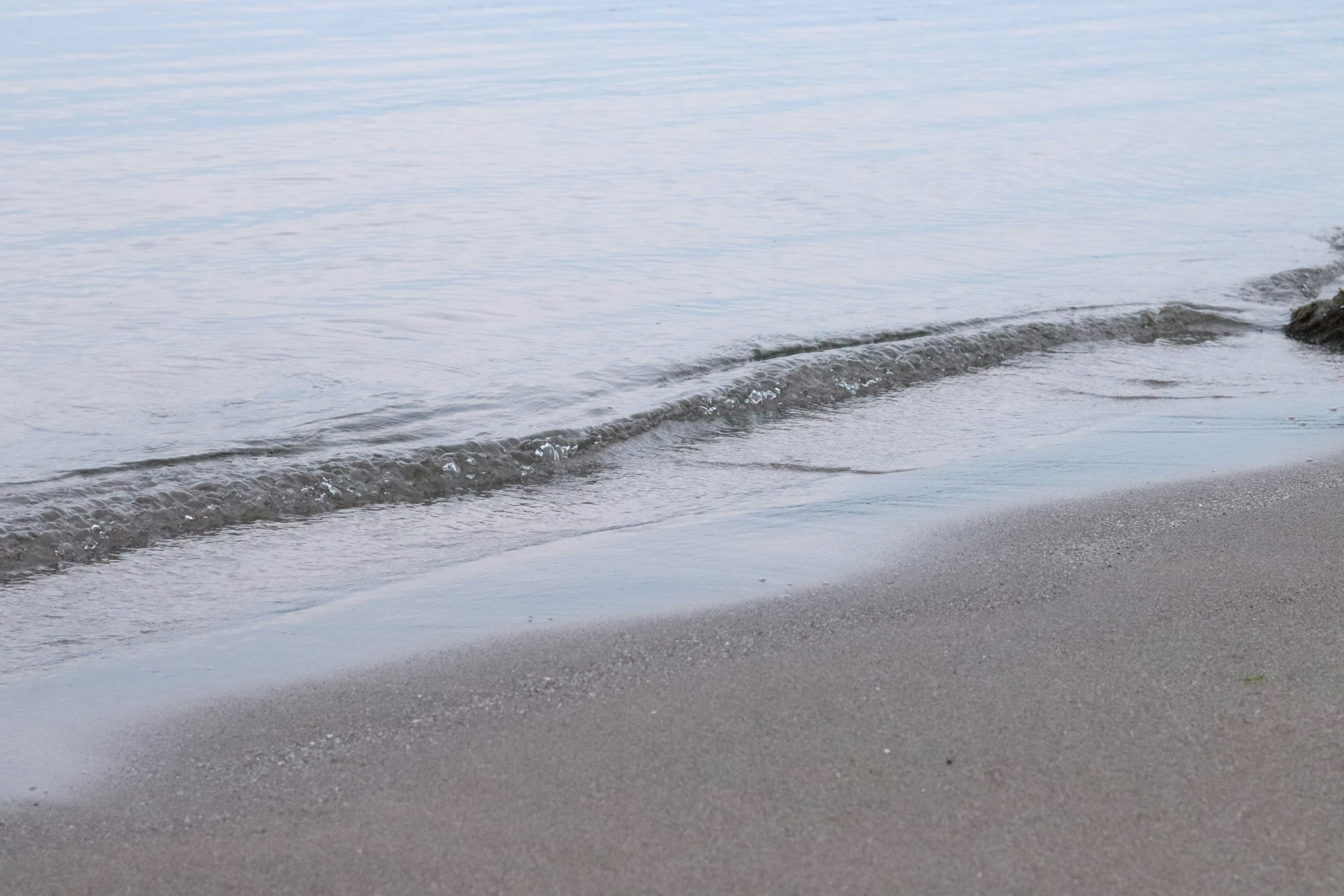 平静的海浪轻轻拍打着沙滩