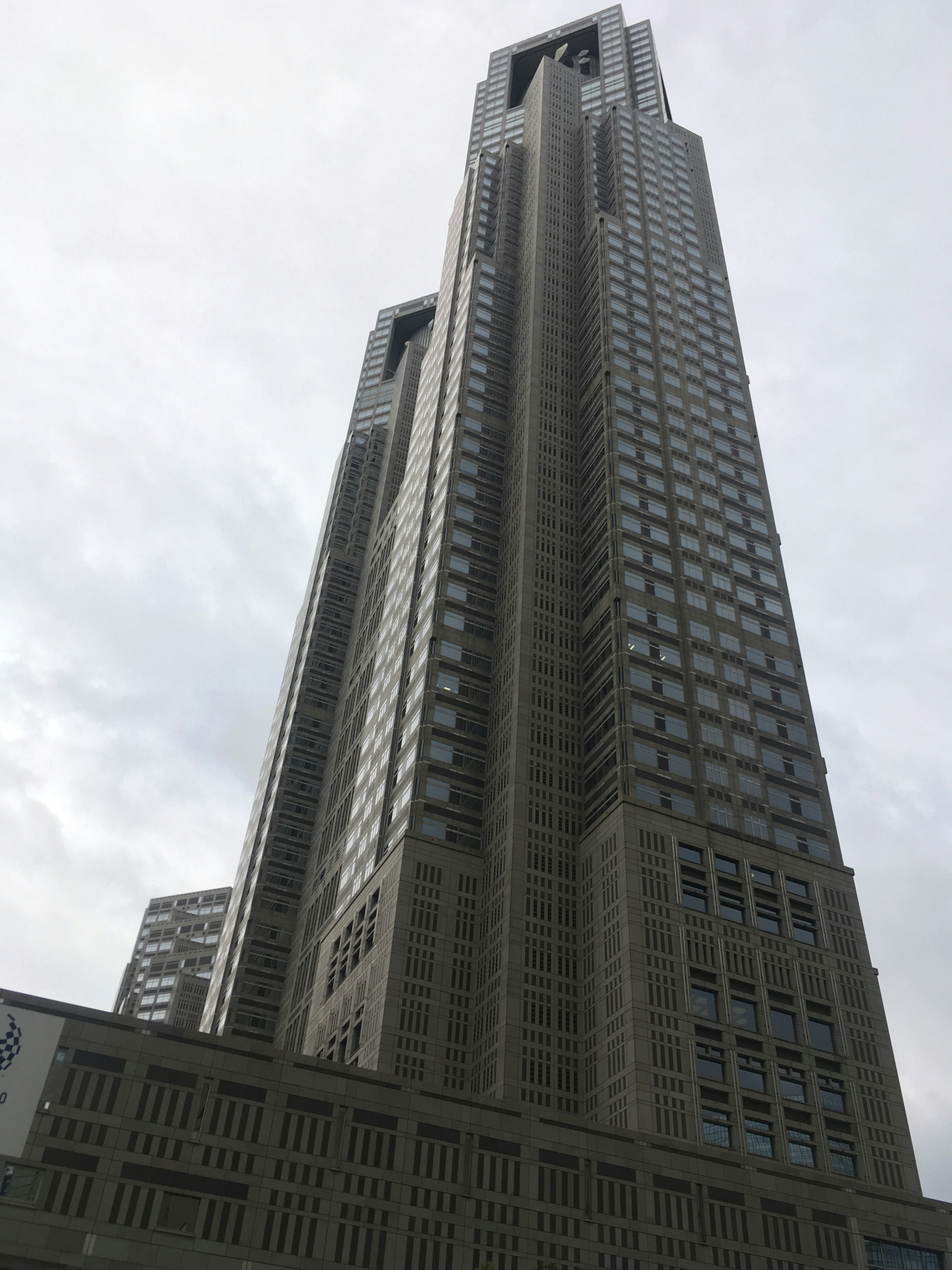 View of a skyscraper from below against a gray sky