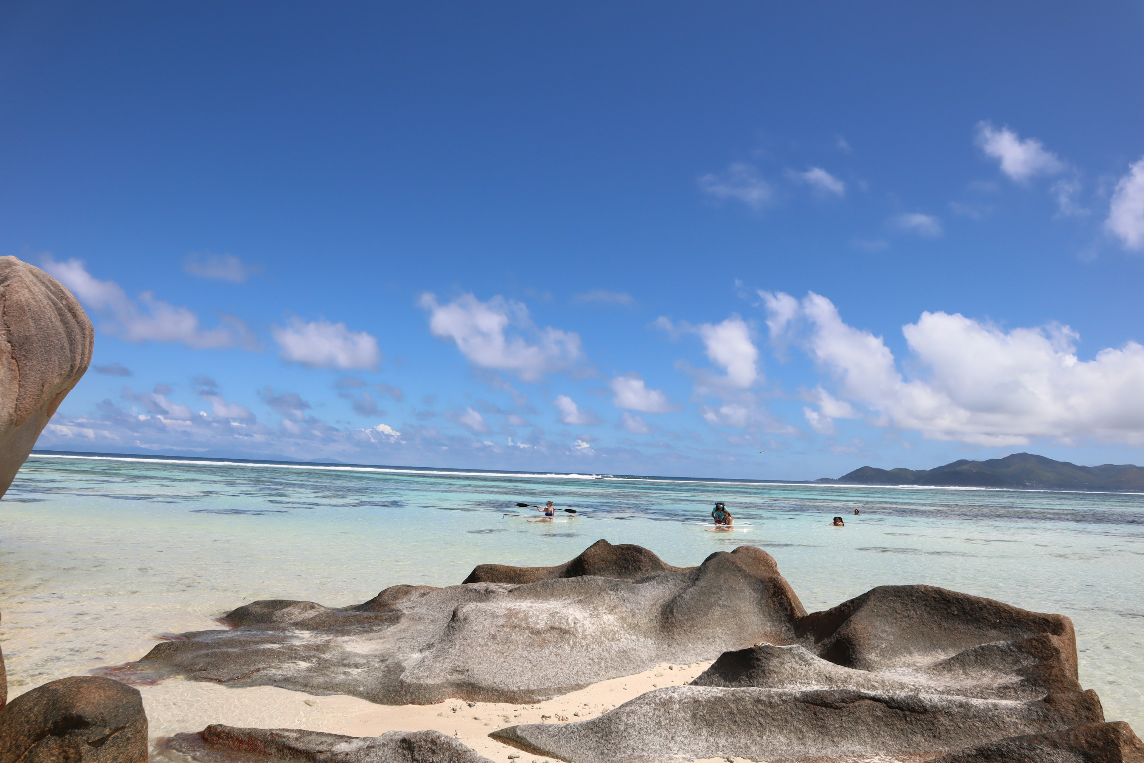 Schöne Strandlandschaft mit blauem Himmel und weißen Wolken mit Felsen und ruhiger See