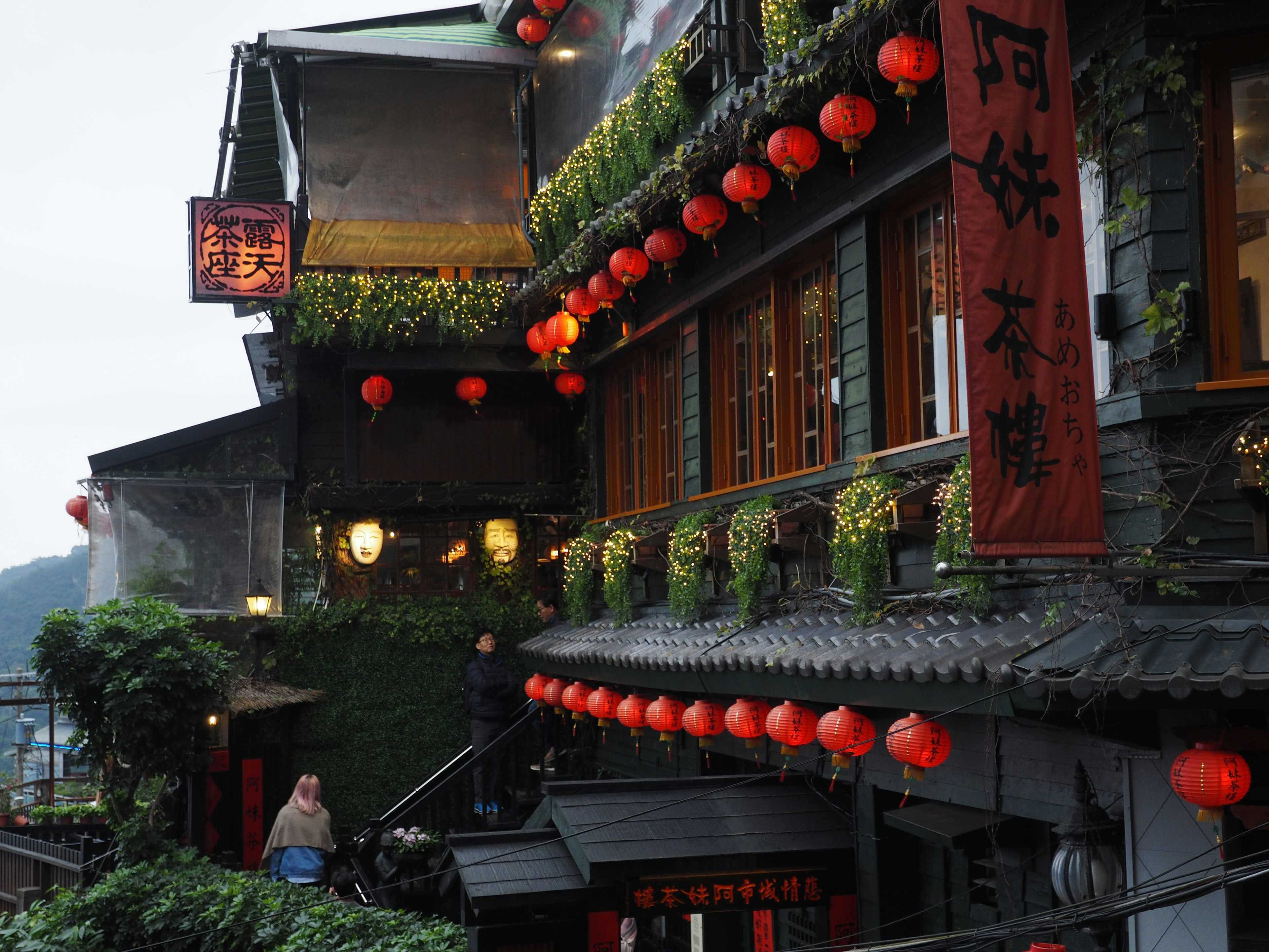 Bâtiment traditionnel chinois orné de lanternes rouges dans une scène de rue nocturne