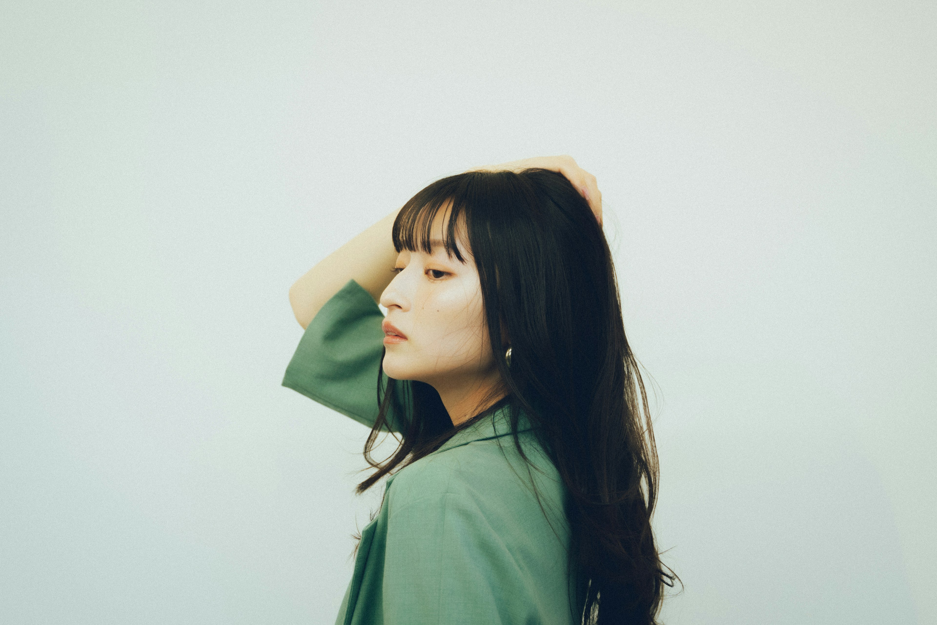 A woman in a green outfit looking sideways