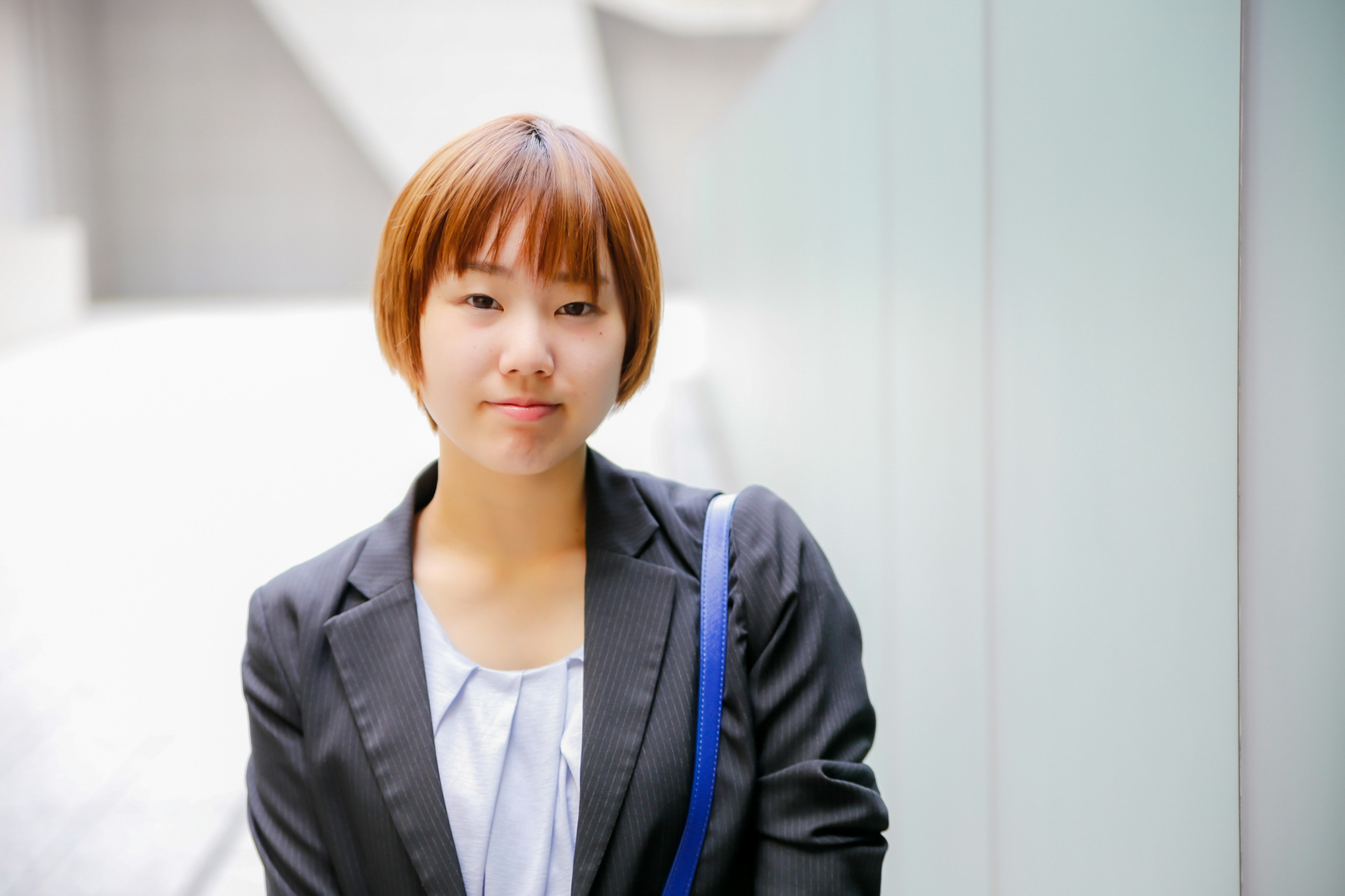 Jeune femme en costume d'affaires souriant doucement