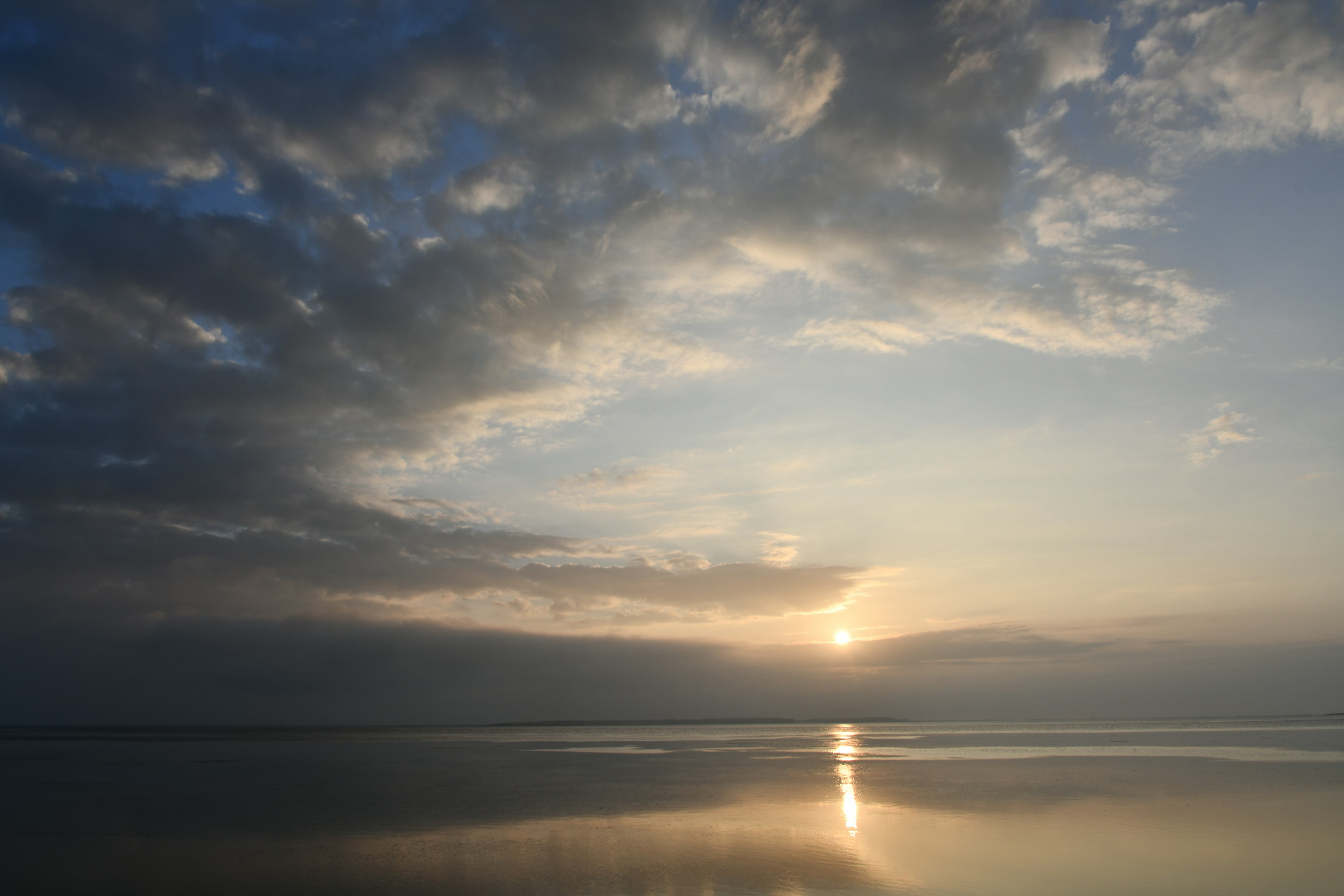 Vue sereine du lac avec des nuages et un coucher de soleil