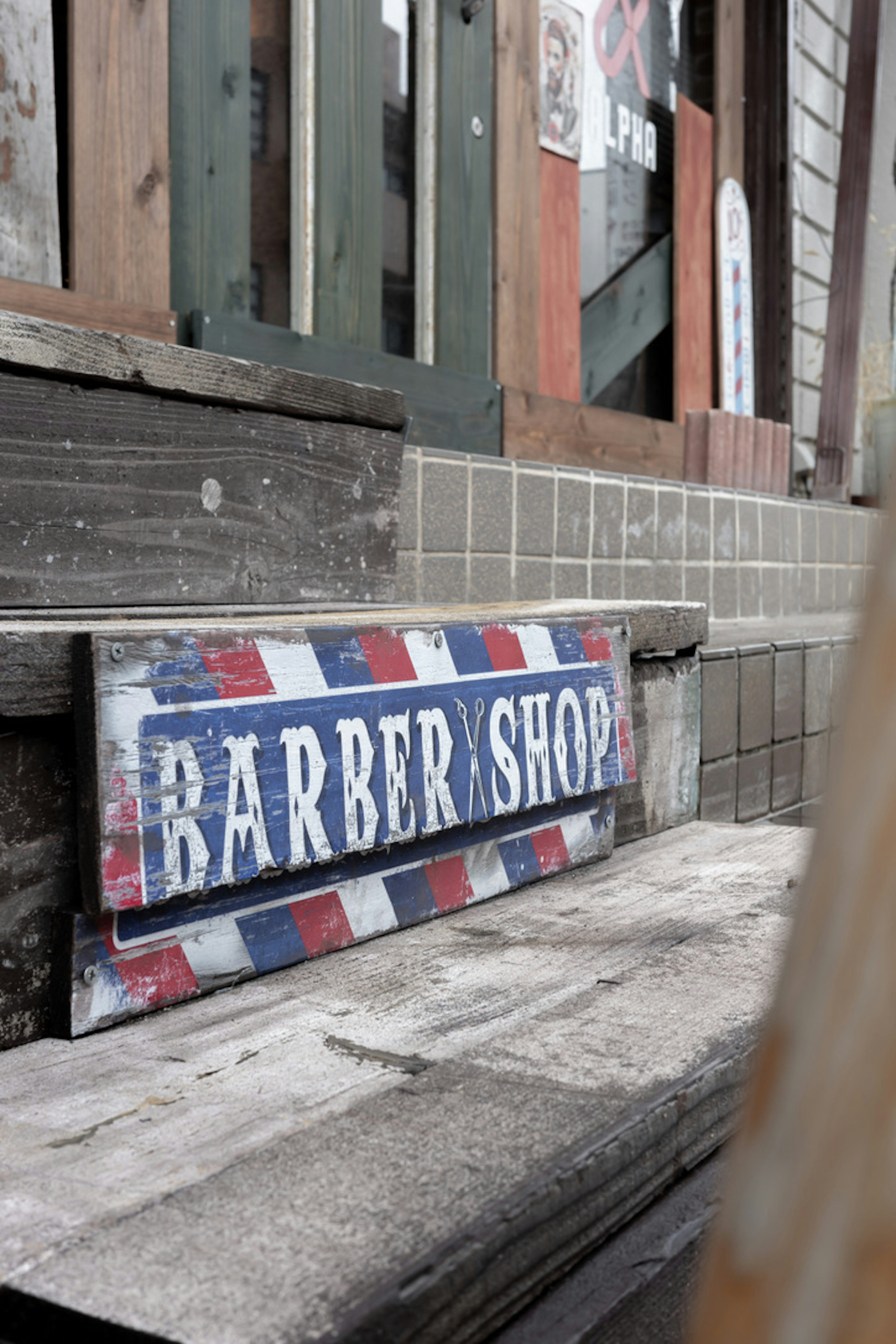 Un vieux panneau de barber shop placé à côté des escaliers