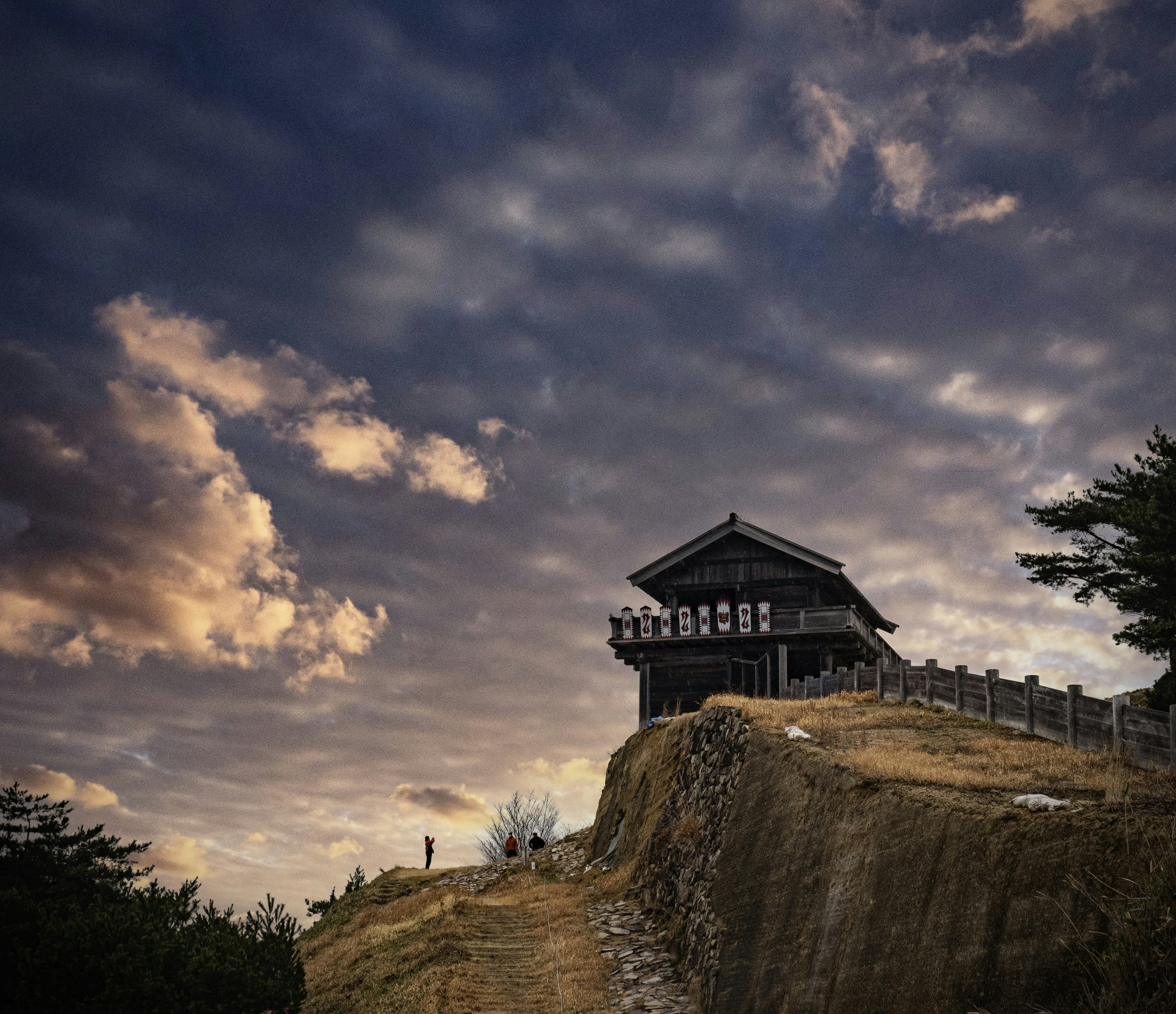 Traditional building on a hill surrounded by beautiful clouds