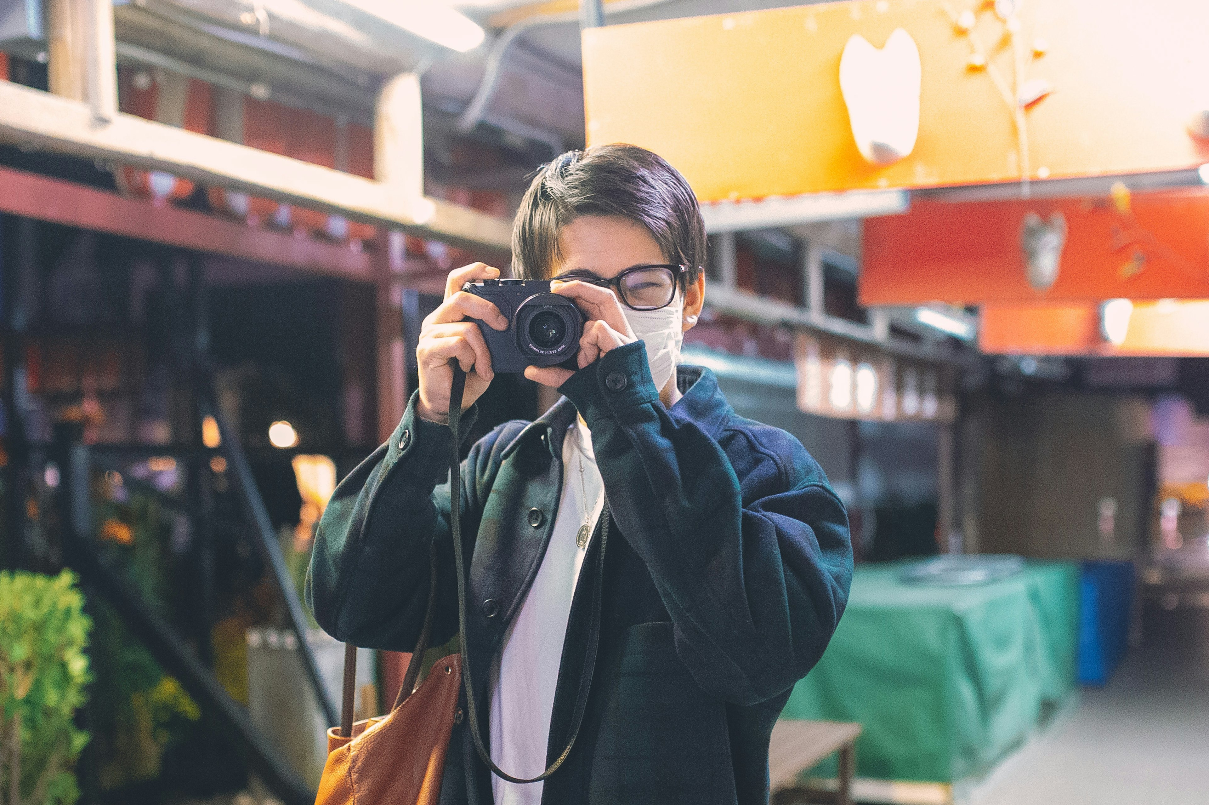 Jeune personne tenant un appareil photo prenant un selfie dans un cadre urbain