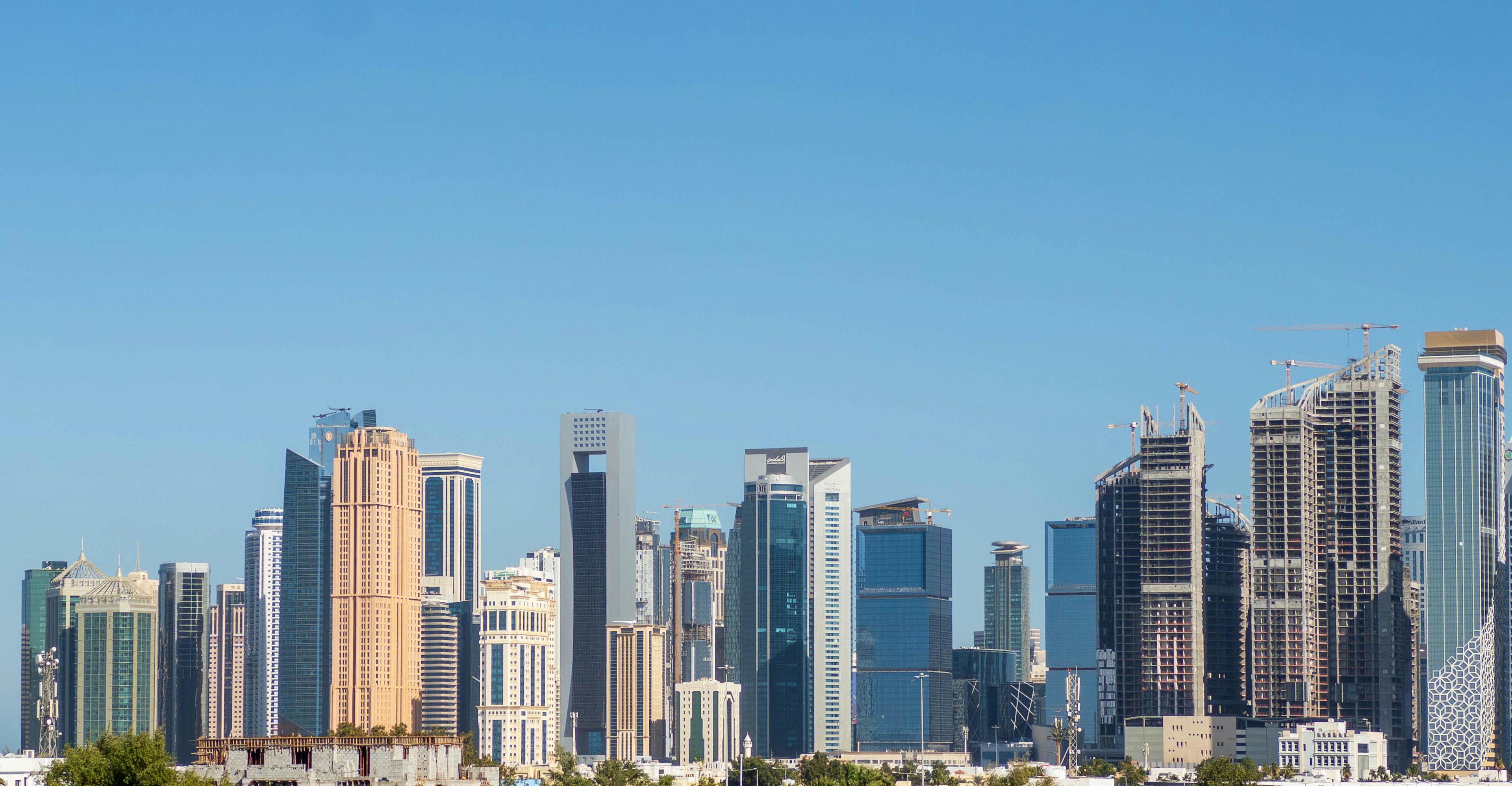 Skyline di una città con alti edifici sotto un cielo blu chiaro